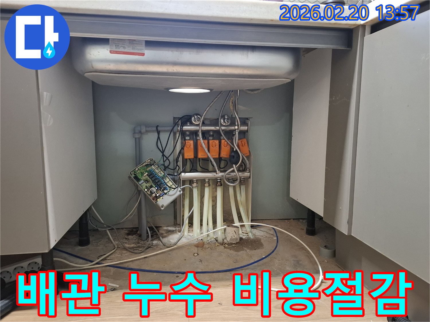 싱크대 하부의 복잡한 배관에서-누수가 발생하여-전문 엔지니어가 비용 효율적인-수리 방법을 제안하고 있습니다