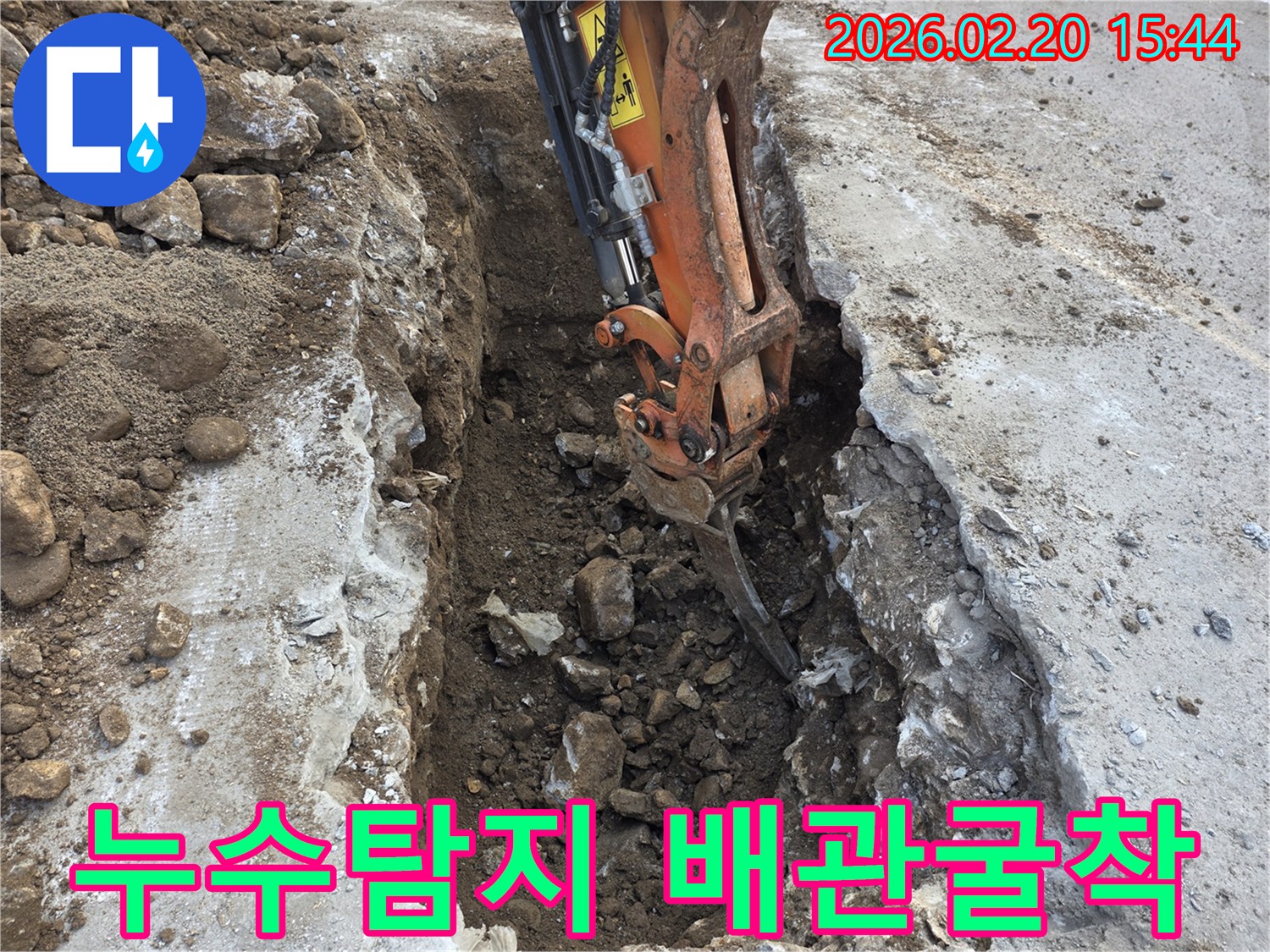 누수-탐지-후-배관-노출을-위해-굴착-장비가-땅을-파고-있는-공사-현장