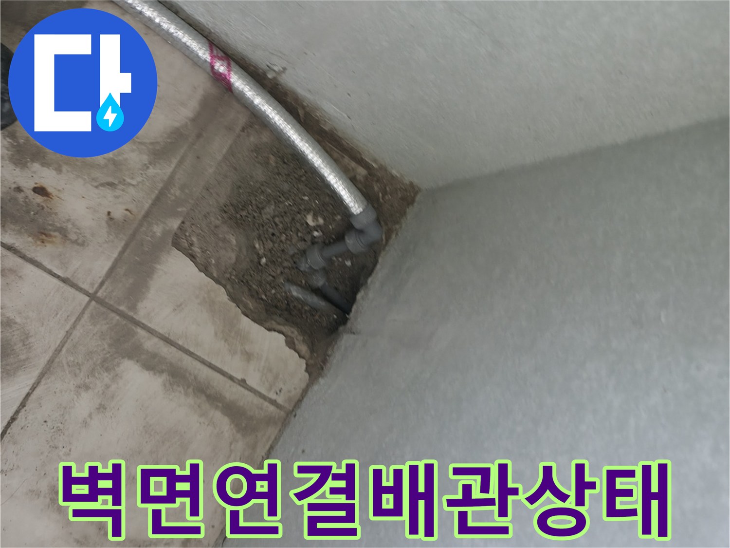 벽과 바닥 경계에 노출된 금속 수도 배관