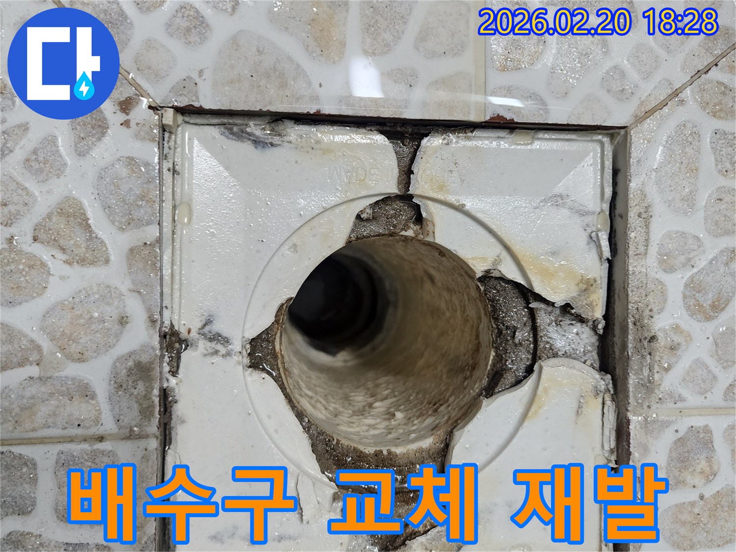 이 이미지는-오래된 욕실 배수구의 심각한 파손으로-주변 방수층이 손상되어-누수가 발생하고 있는-현장을 보여줍니다