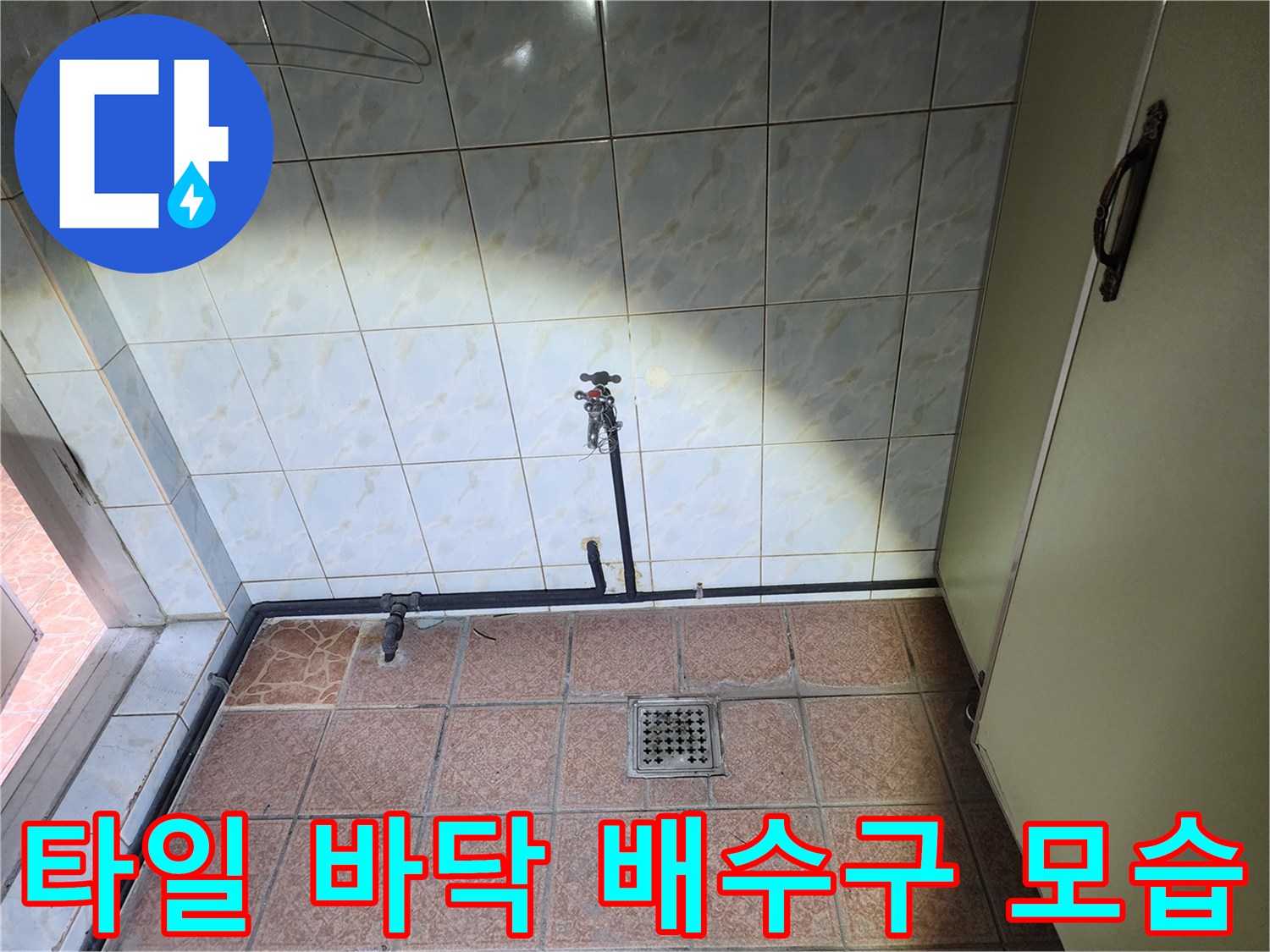 베이지색 타일 바닥에 설치된 금속 재질의 배수구와 밸브