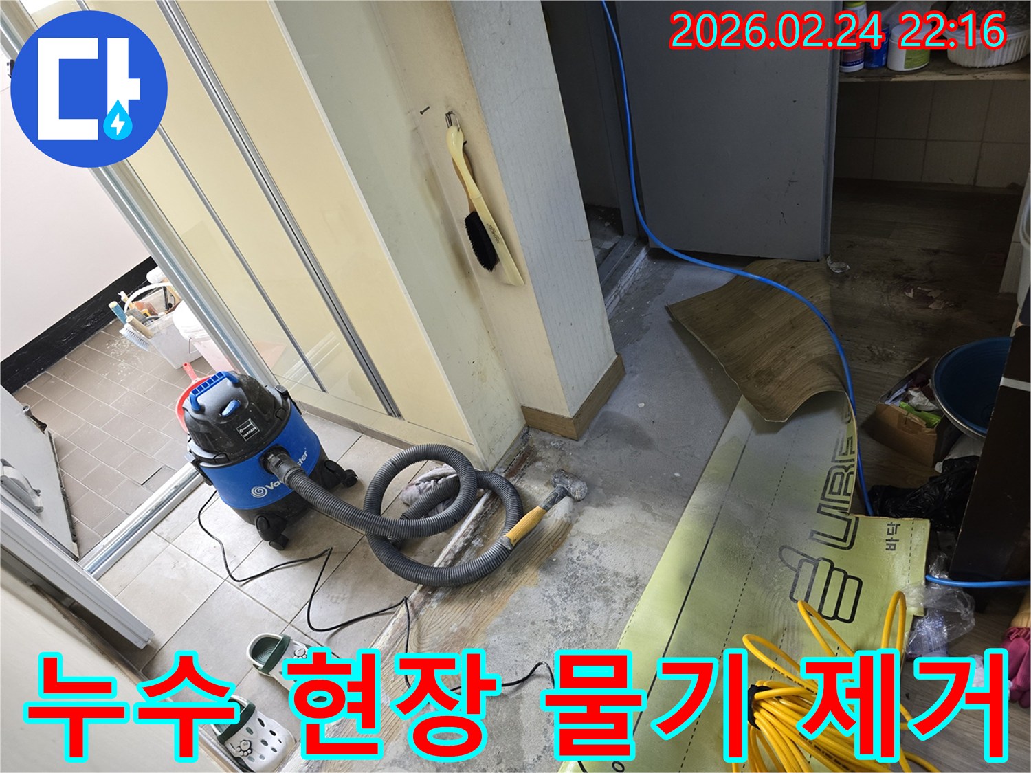 누수 지점에서 물기를 효과적으로 제거하기 위해-강력한 습식 청소기를 사용하는-공사 현장입니다.