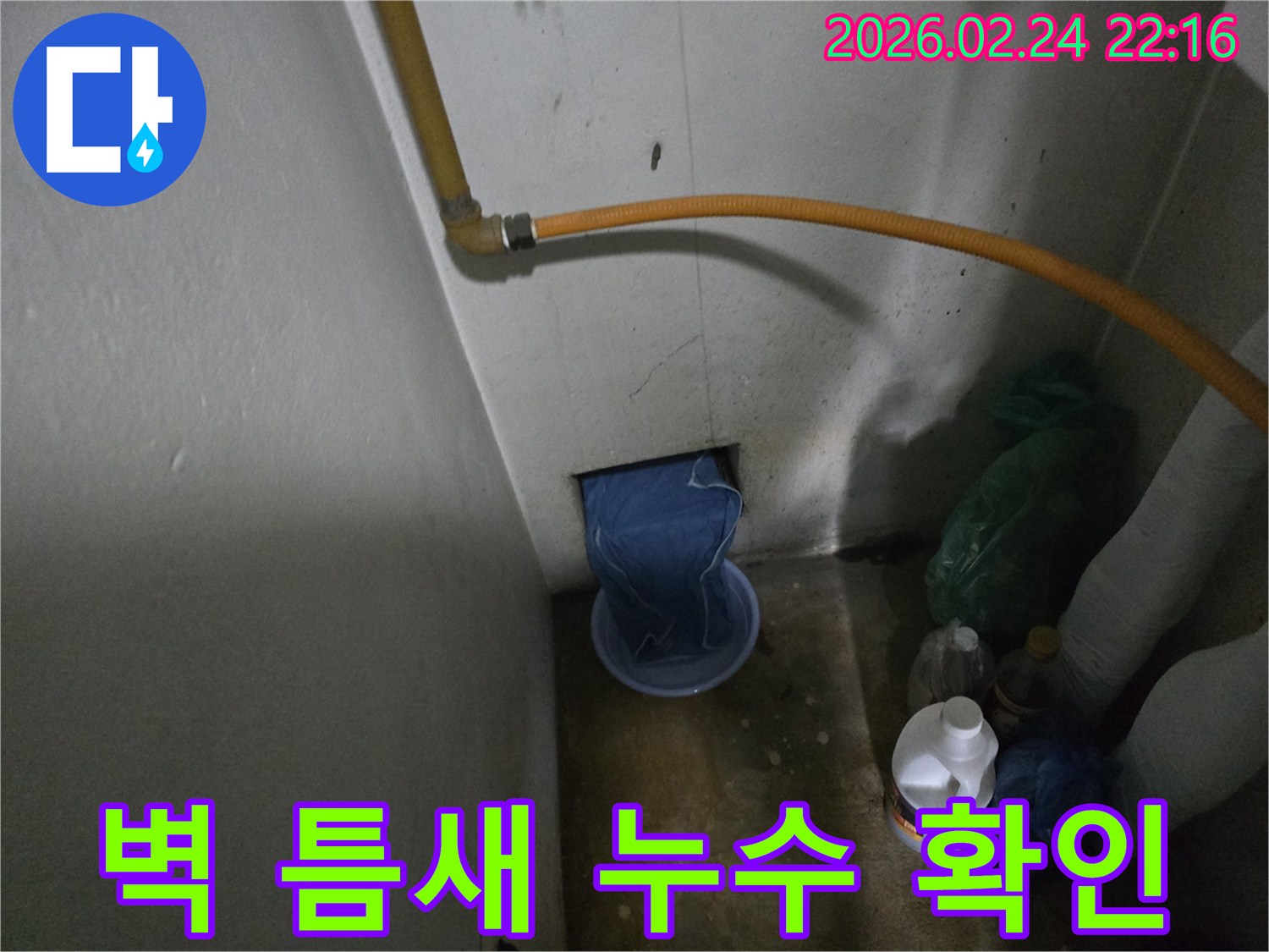 벽-하단부에서-물이-새어-나와-임시-용기에-받아지고-있는-누수-발생-장면