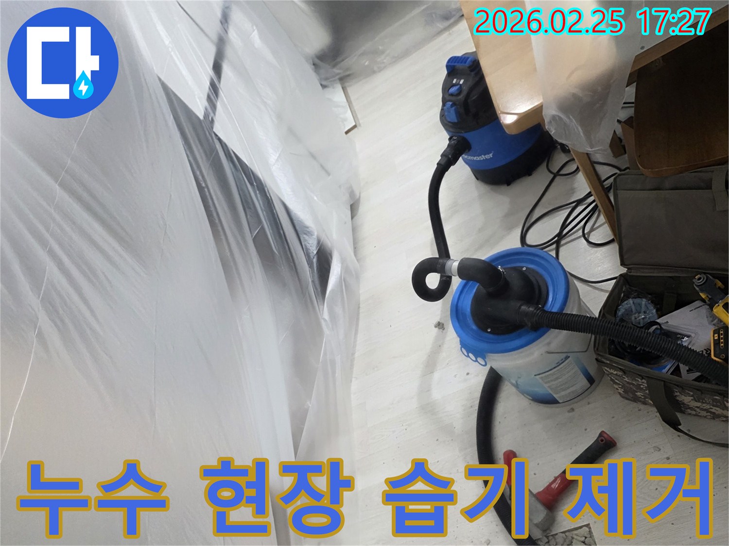 누수 발생으로 개방된 바닥과-습기 제거를 위한-전문 장비가 설치된-작업 현장입니다