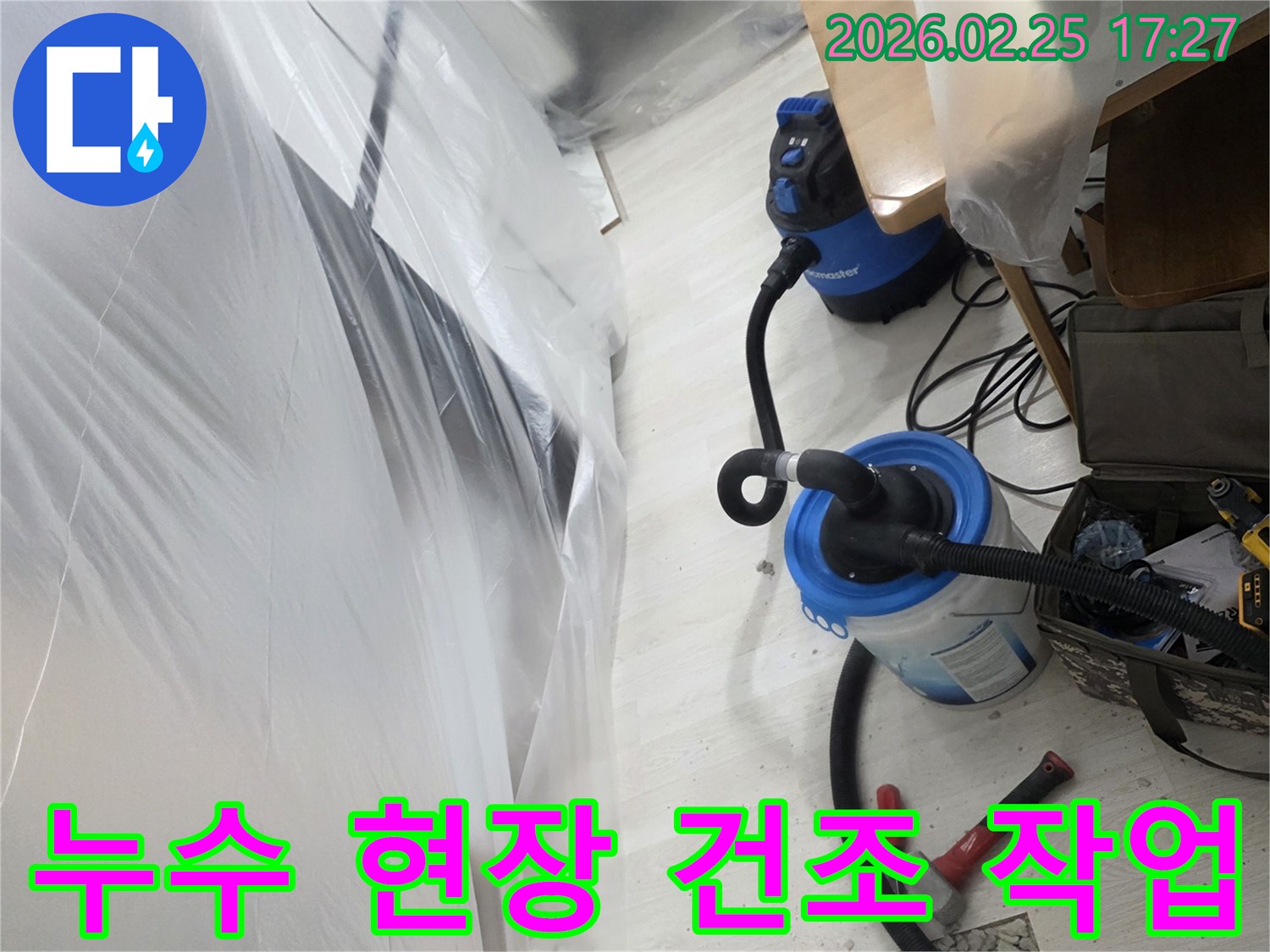 누수 발생으로 개방된 바닥과-습기 제거를 위한-전문 장비가 설치된-작업 현장입니다
