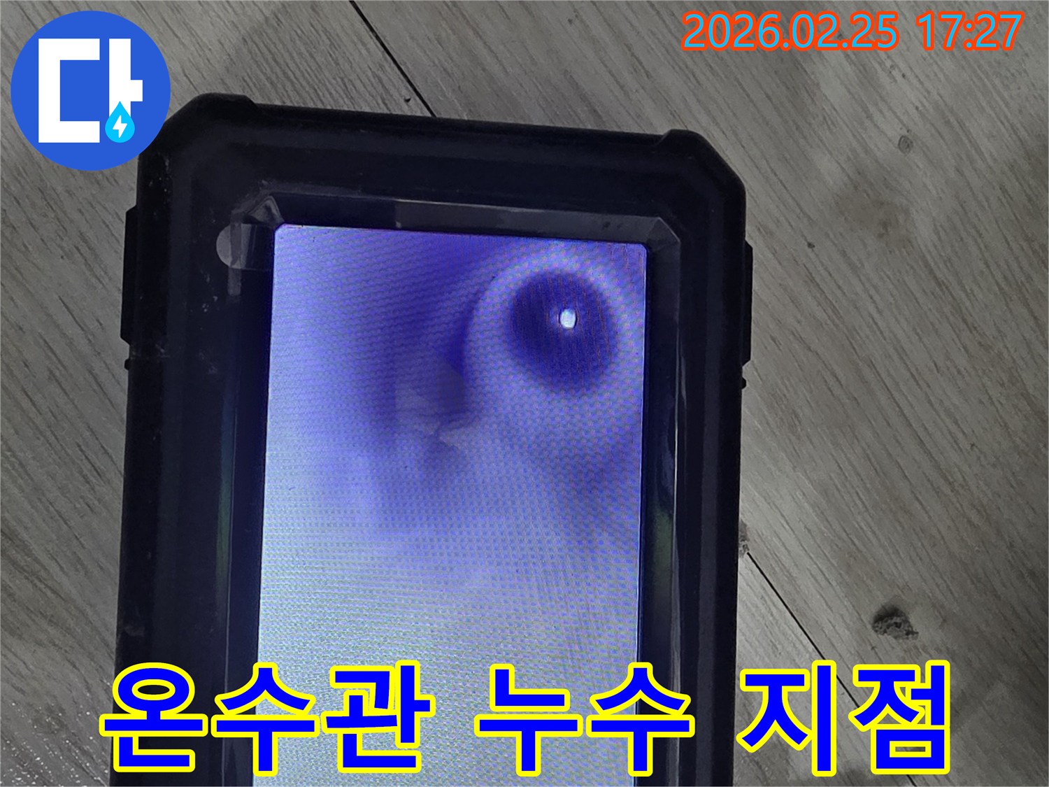 이 이미지는 누수 탐지 작업 중-내시경 카메라로 배관 내부를 확인하는-장면을 보여줍니다
