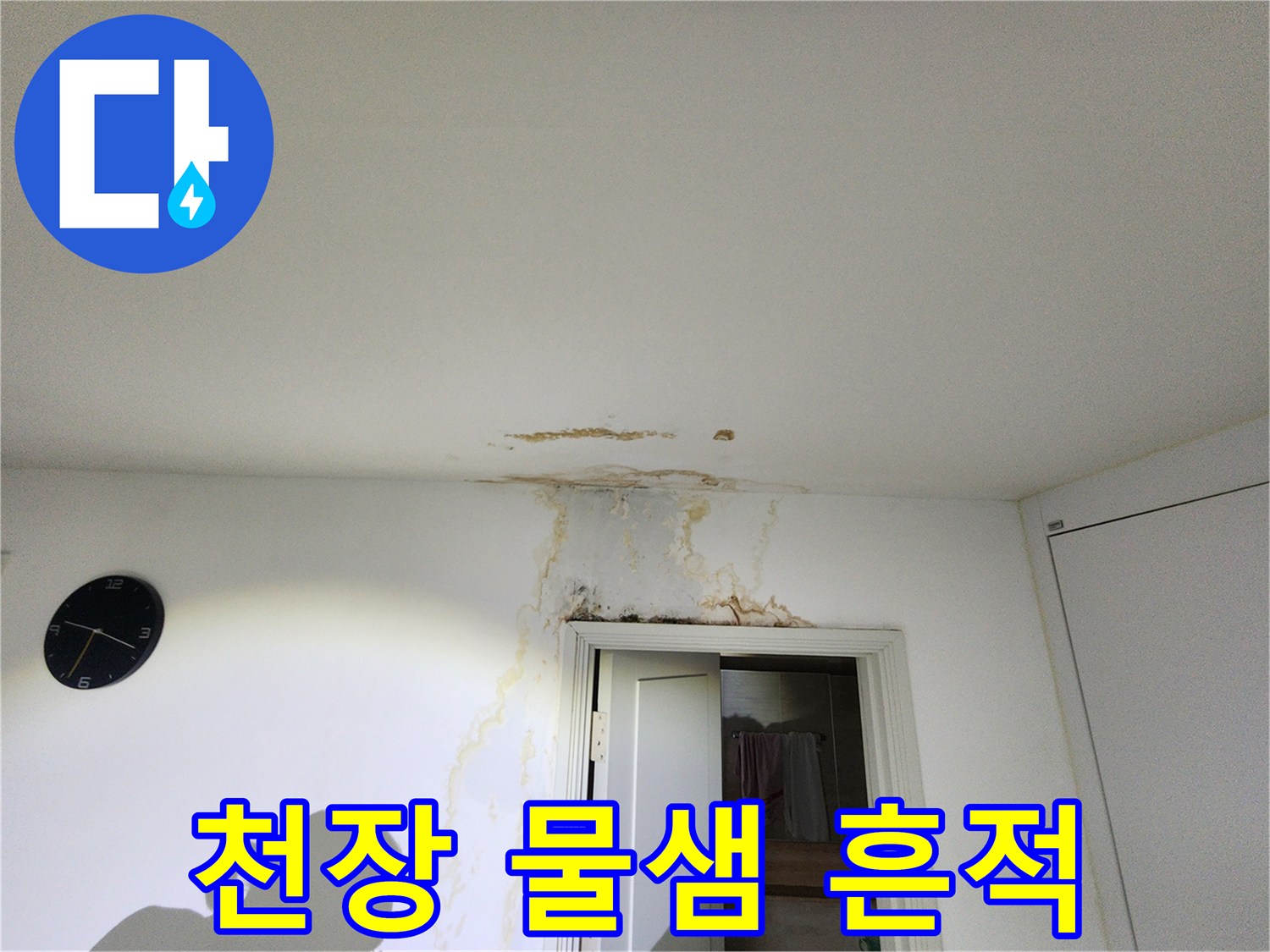문 위쪽 천장 마감재의 누수 얼룩 부위