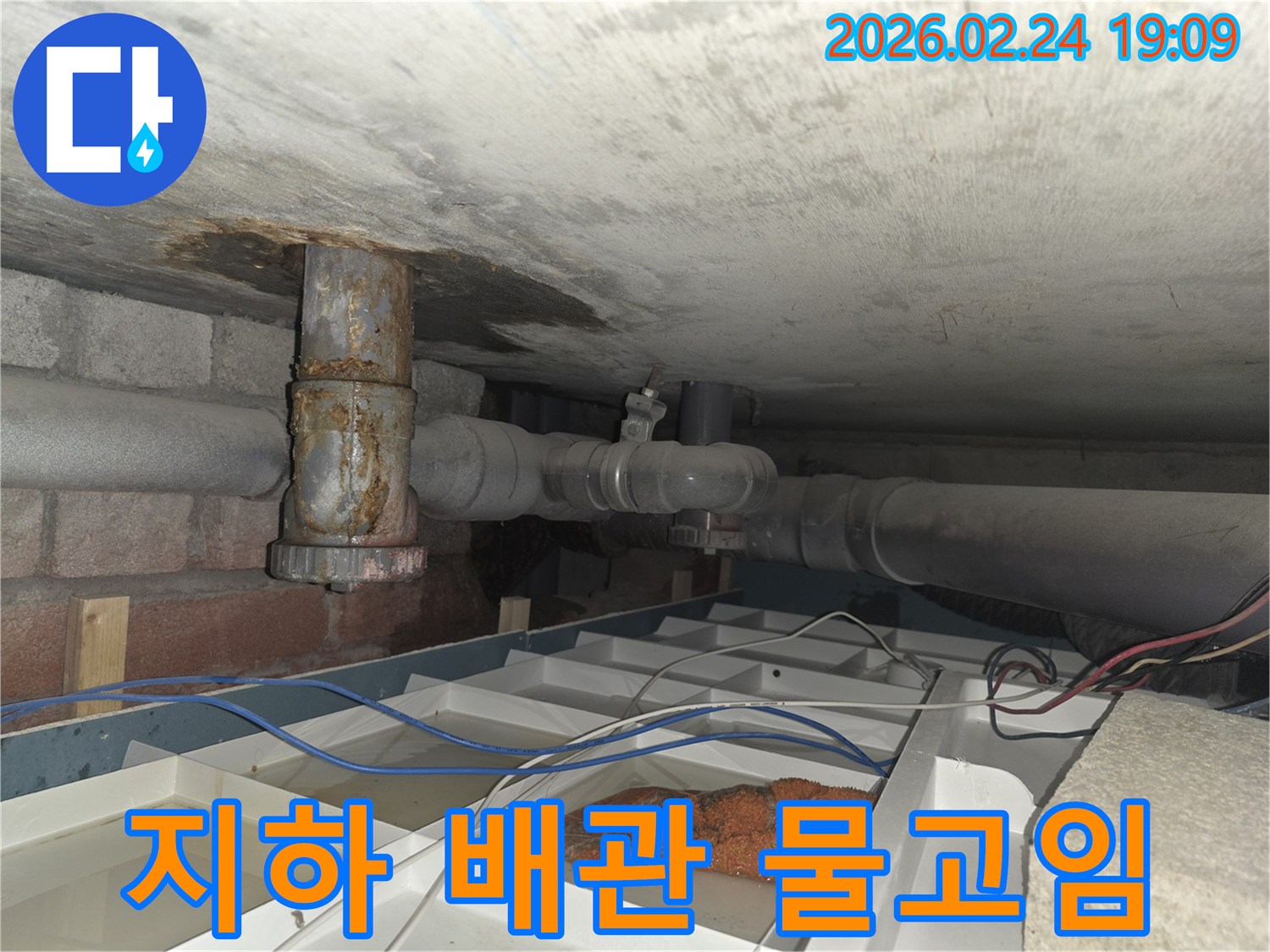 부식된 배관에서 물이 새어 나와 임시로 물을 받고 있는 누수 현장