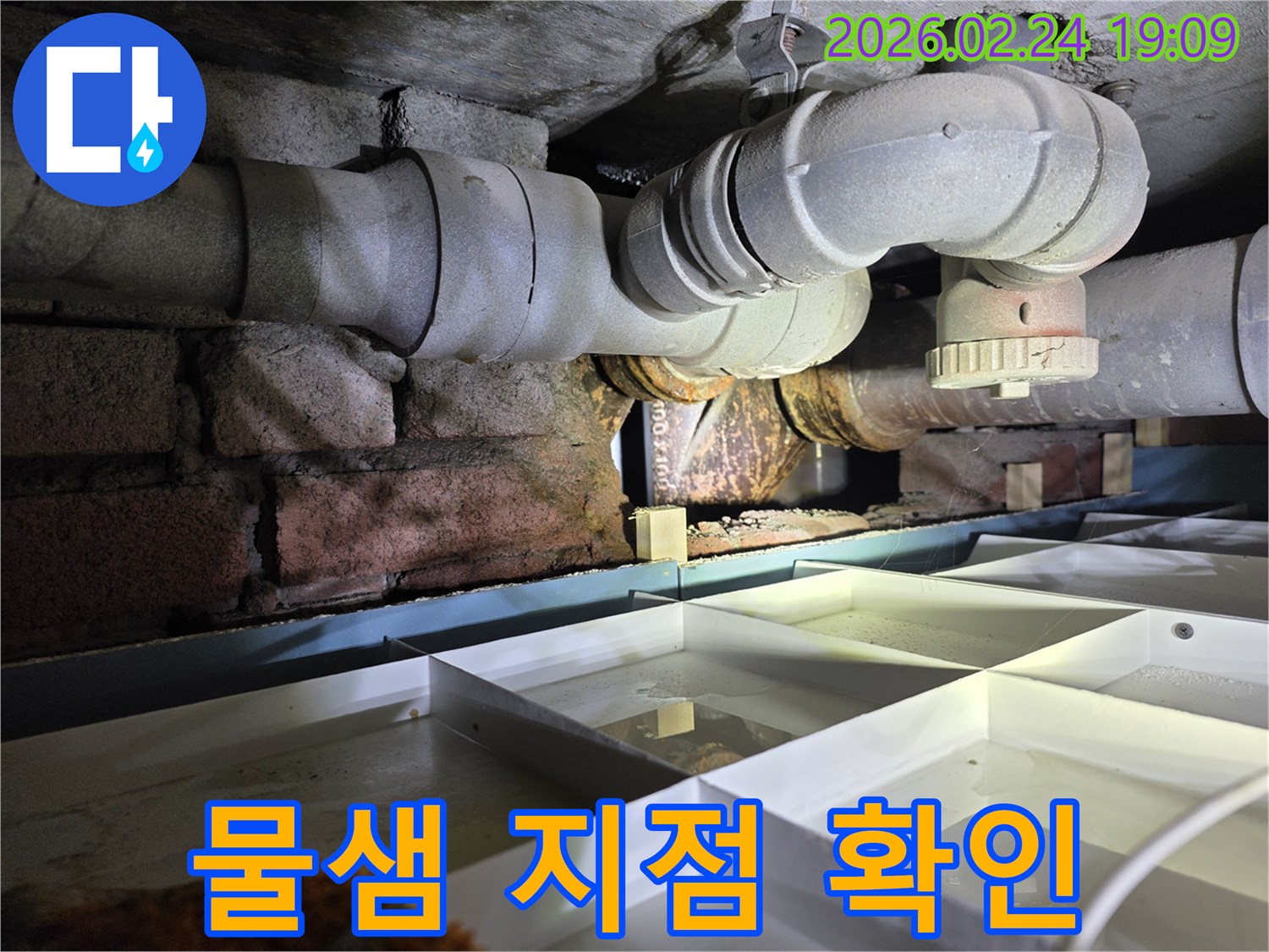 좁은-공간에-위치한-노후-배관에서-물이-새어-나와-고이는-현장을-보여주는-사진