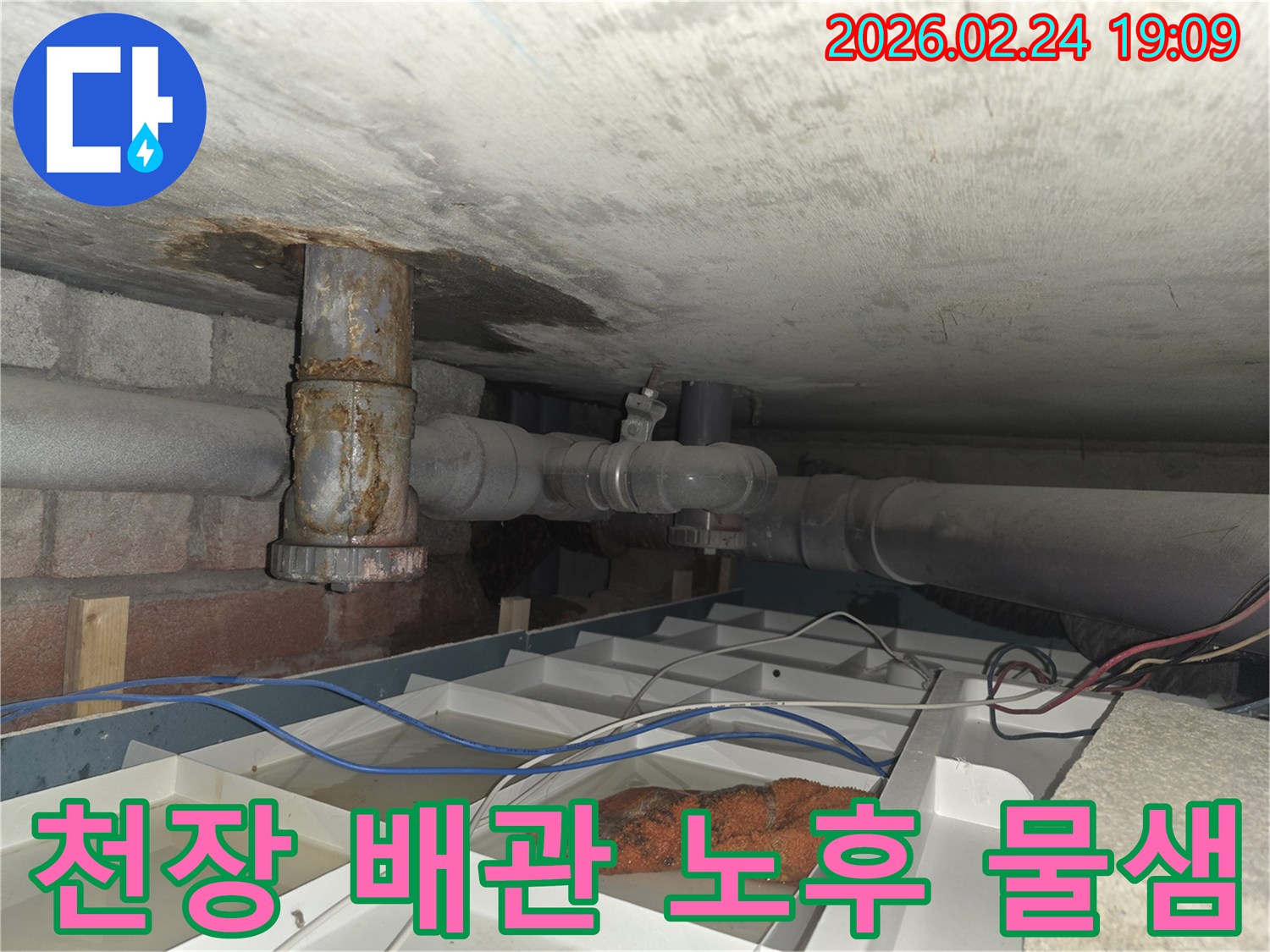 천장 아래의-오래된 배관에서-물이 새어 나와-임시 용기에-고여있는 현장 모습