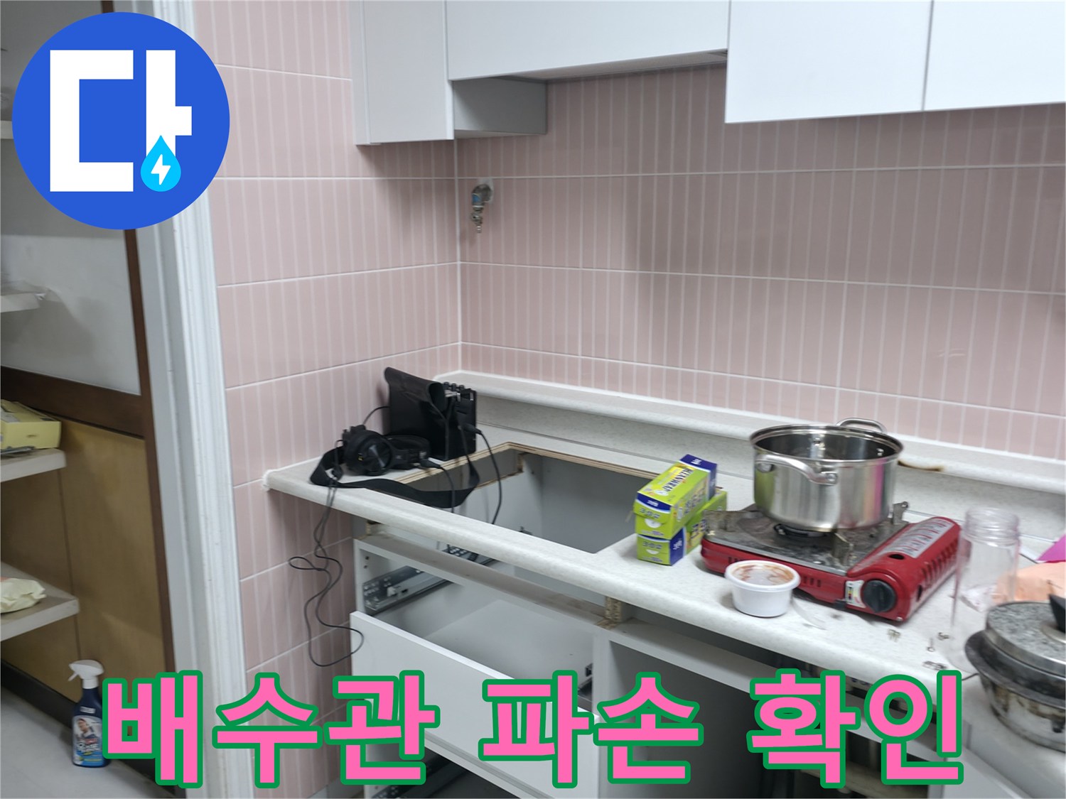 싱크대 아래쪽-배관 주변의 물샘 현상을 면밀히 관찰하는 모습입니다.