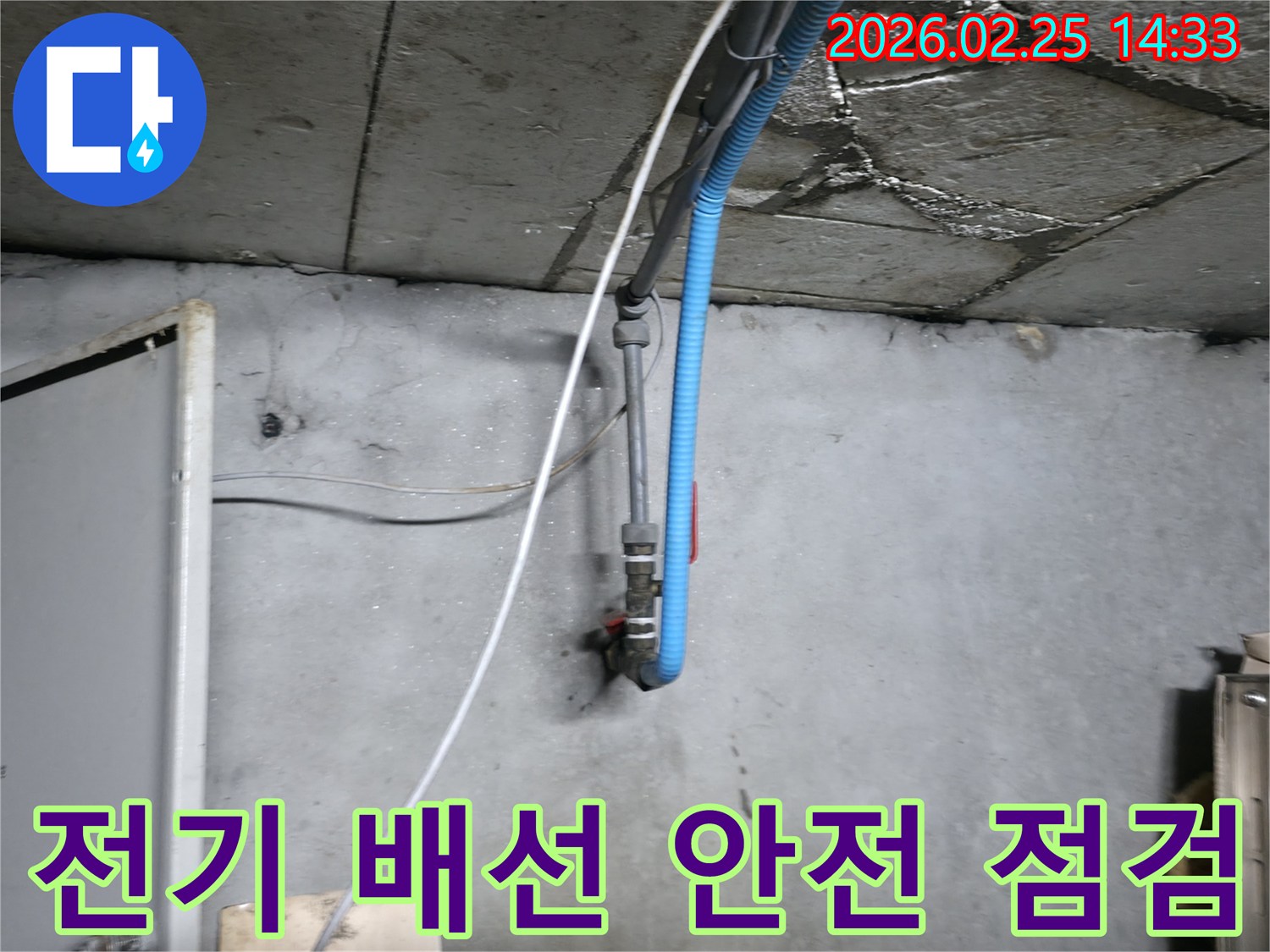 물기가 스며든 천장 배관과-인접한 전기 배선의-안전 상태를 점검하는 모습
