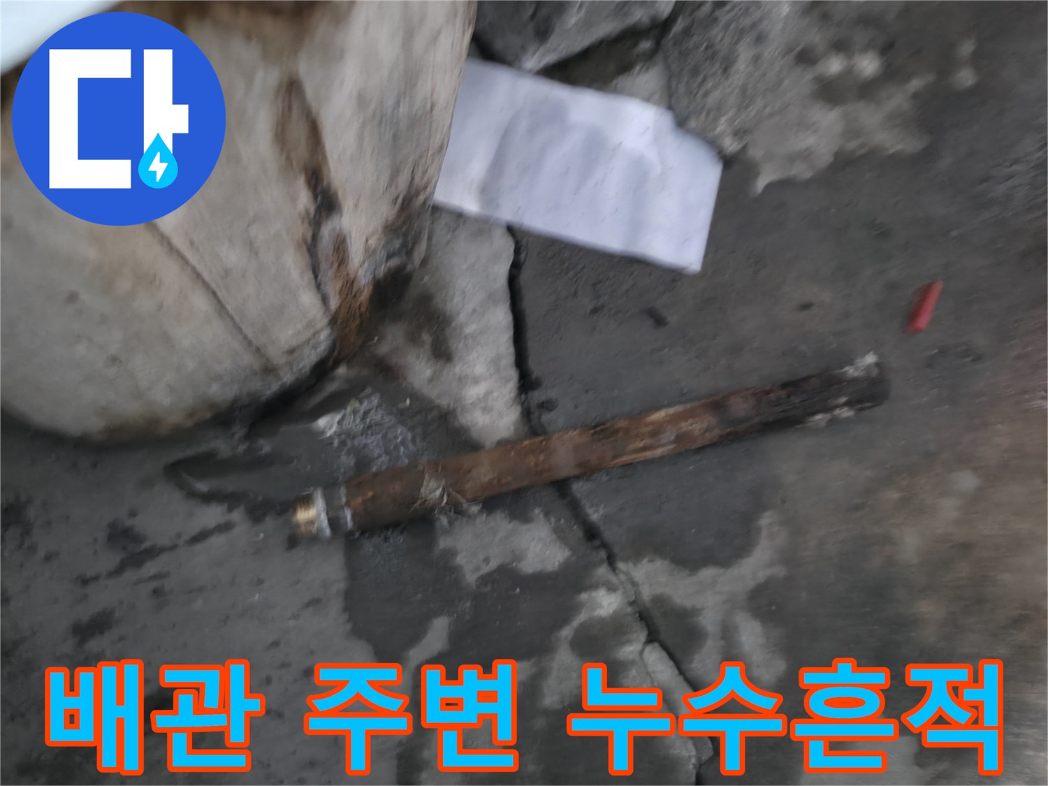 배관 근처 콘크리트 바닥의 젖은 흔적과 물고임