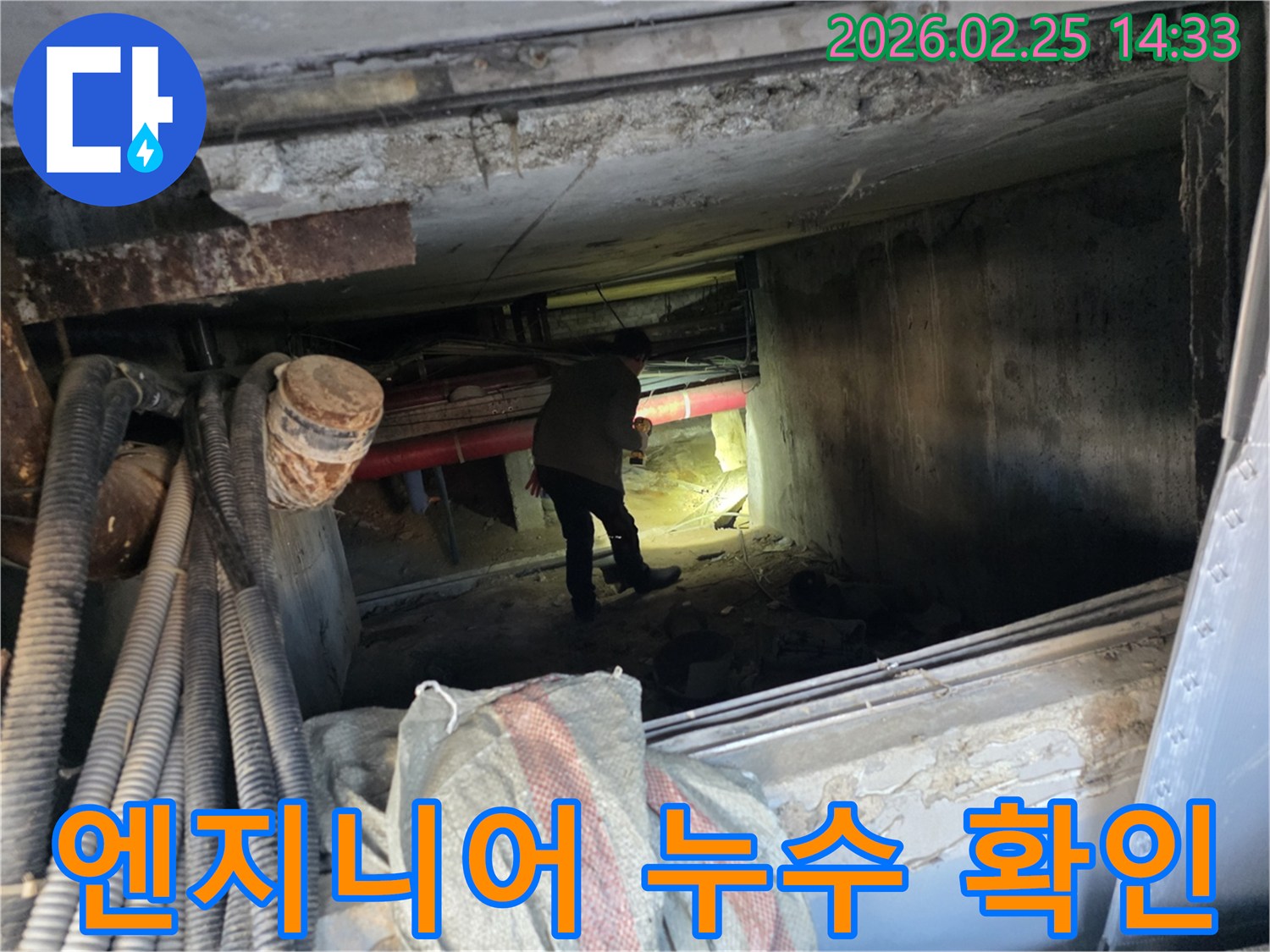 손전등을 든-누수 전문가가-복잡한 배관 사이에서-누수 지점을-확인하는 중