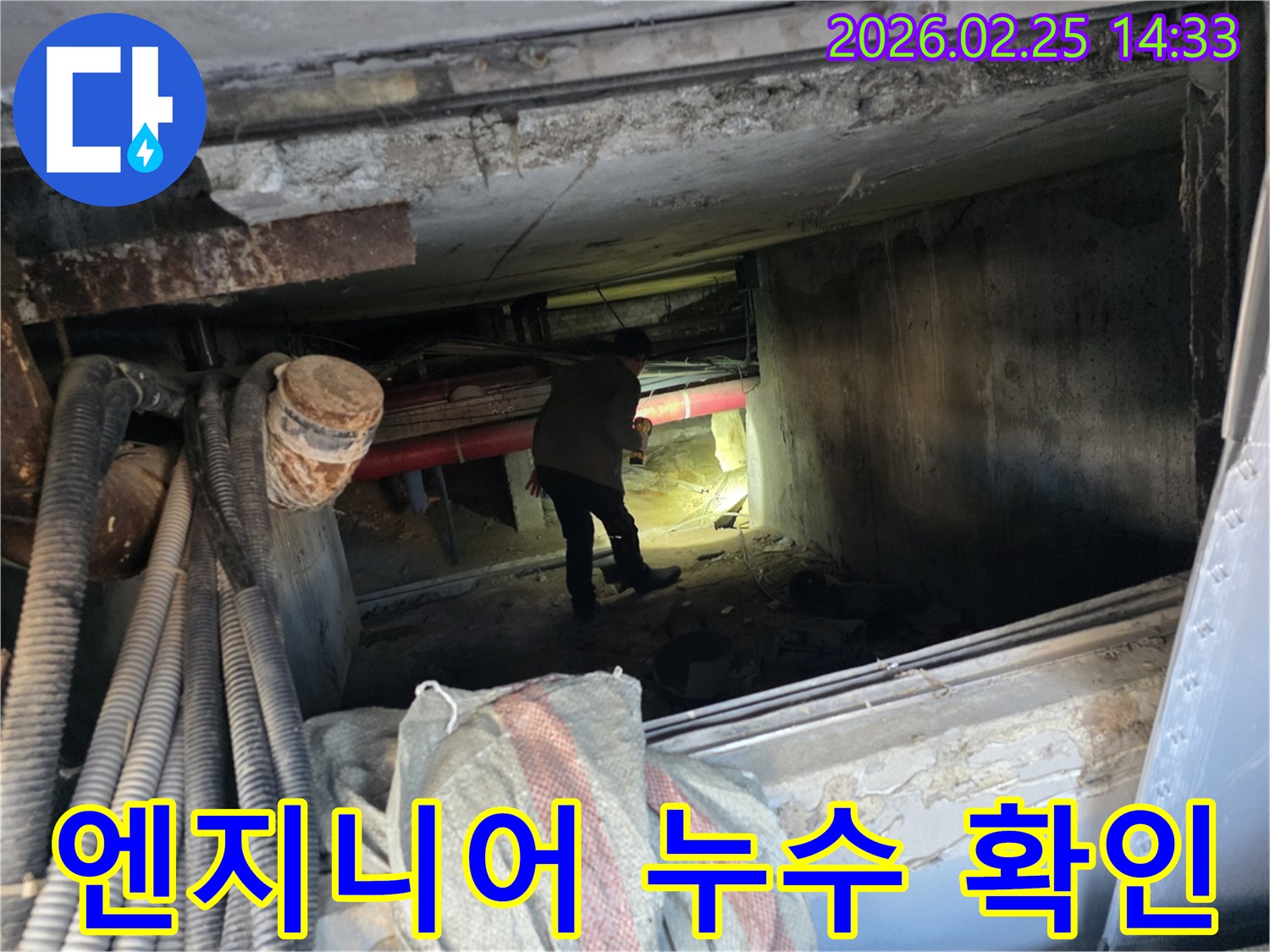 손전등을 든-누수 전문가가-복잡한 배관 사이에서-누수 지점을-확인하는 중