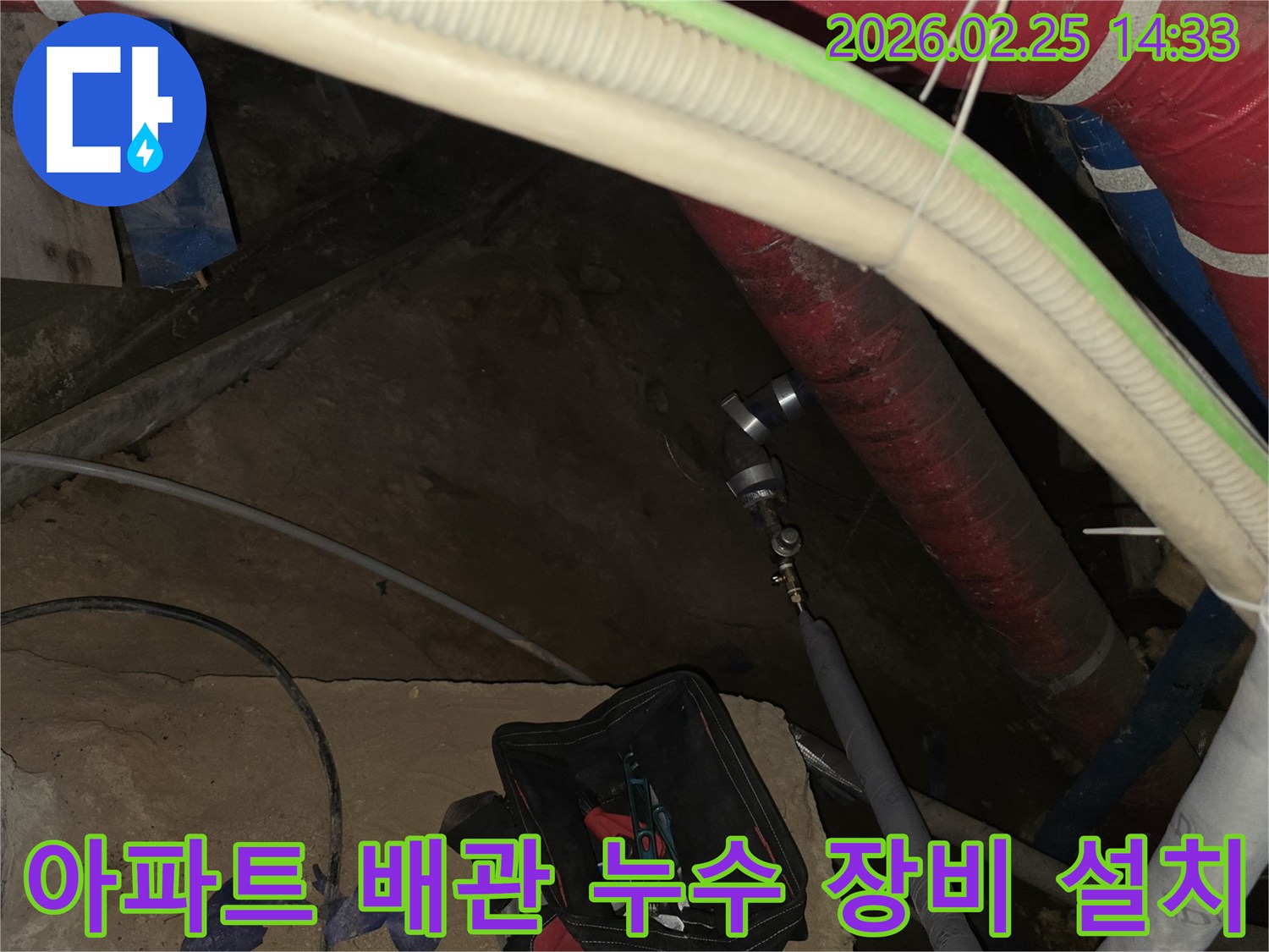아파트 누수 원인을 파악하기 위해-배관에 정밀 진단 장비를 설치하는-전문가의 손길입니다.