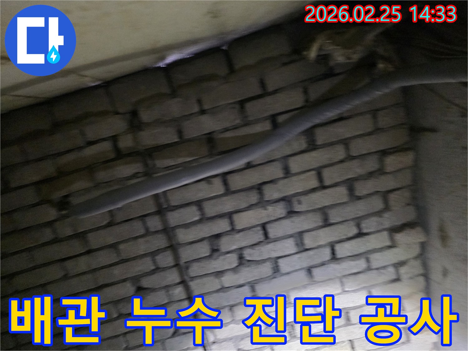 어두운 벽돌 벽면을 배경으로-단열재로 감싸인 배관에서-누수 여부를 정밀 진단하고-공사를 준비하는 현장 이미지입니다.