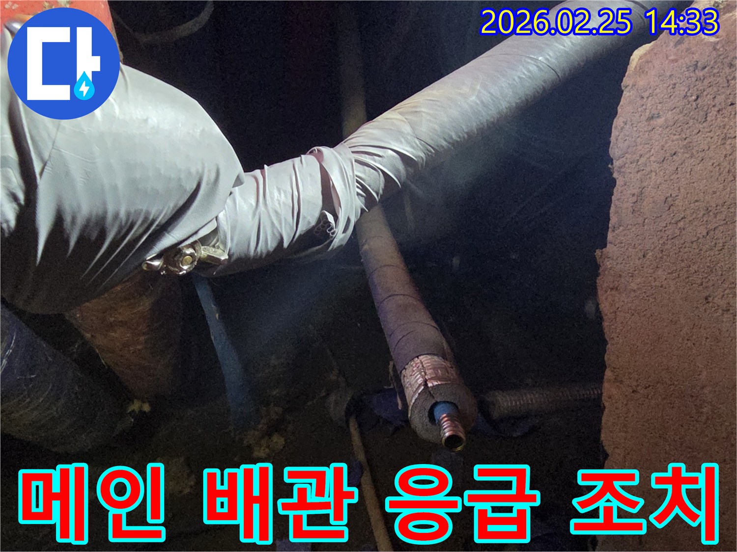 어두운 작업 공간에서-장갑을 낀 손이-메인 수도 배관의-누수 지점을-신속하게 확인하고-응급 조치를-취하는 모습입니다