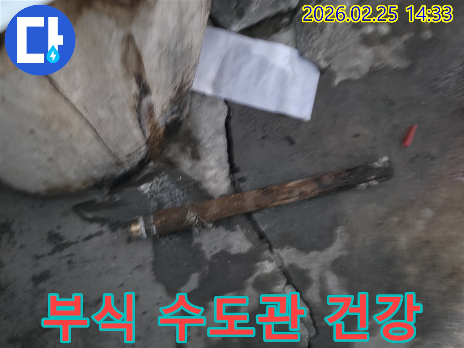 오래되어 부식된-파열된 수도관이-젖은 바닥에 놓여있는-누수 공사 현장 사진입니다.