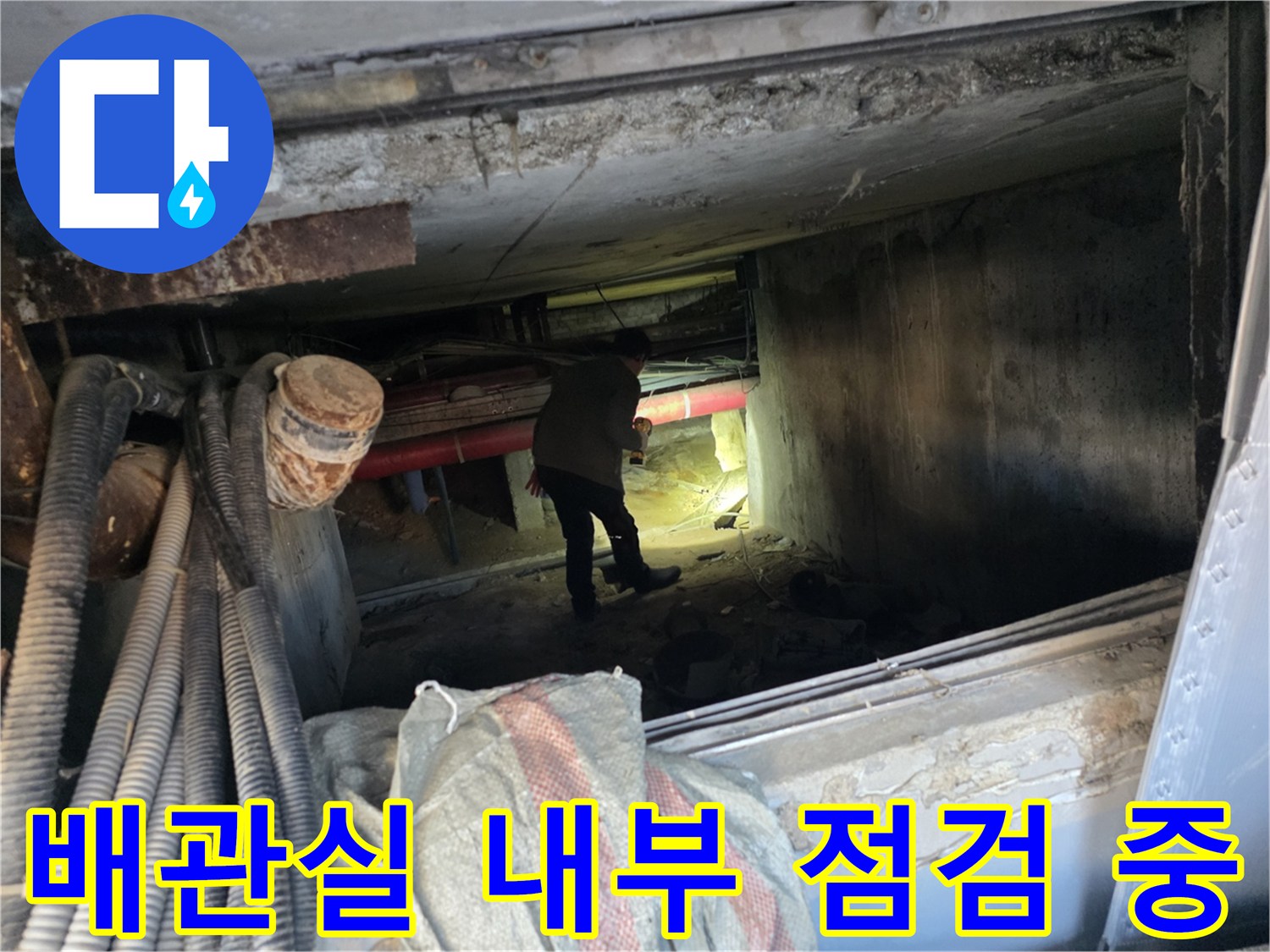 지하 배관실의 좁은 공간에서 배관 상태를 확인하는 작업 모습