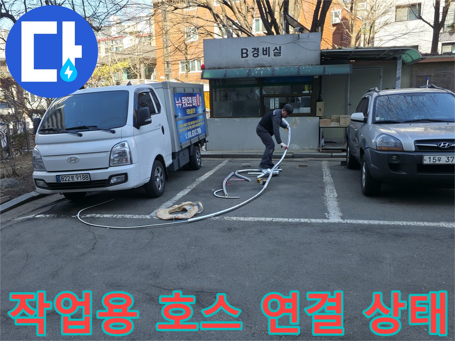 흰색 작업 차량과 바닥에 놓인 긴 점검용 호스 라인
