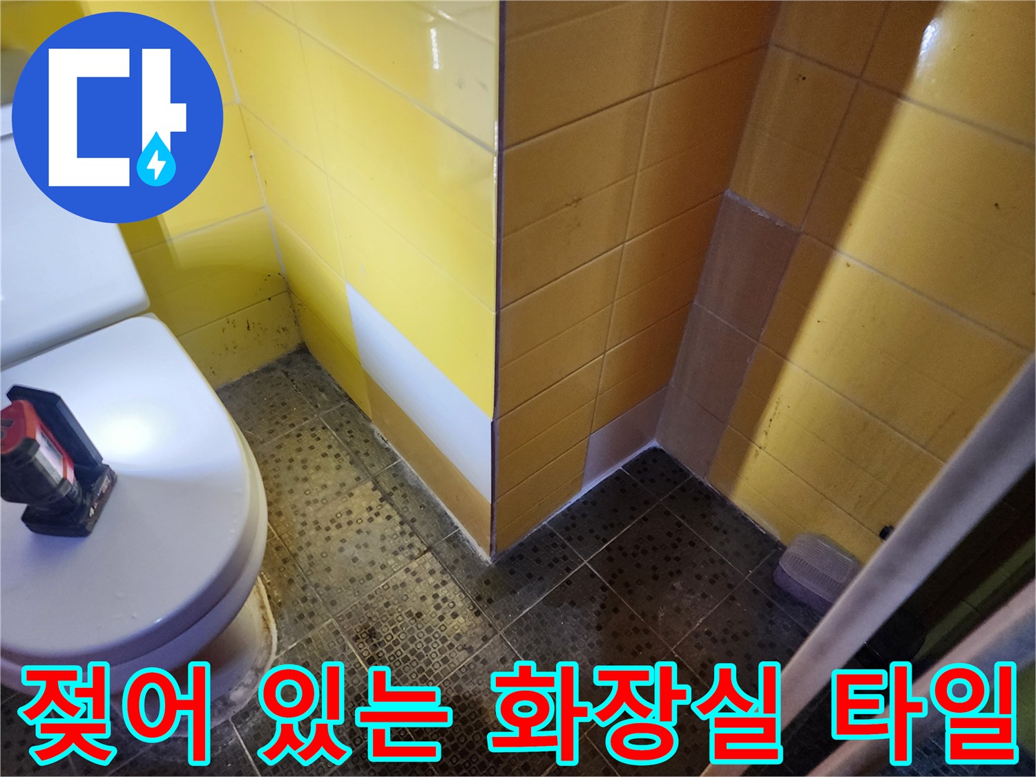 물기가 스며들어 어둡게 변한 화장실 벽면 타일