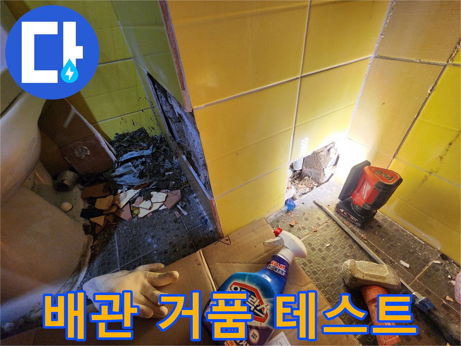 온수 배관 연결 부위의 누수를 확인하기 위해 비눗물을 뿌려 거품을 관찰하는 모습