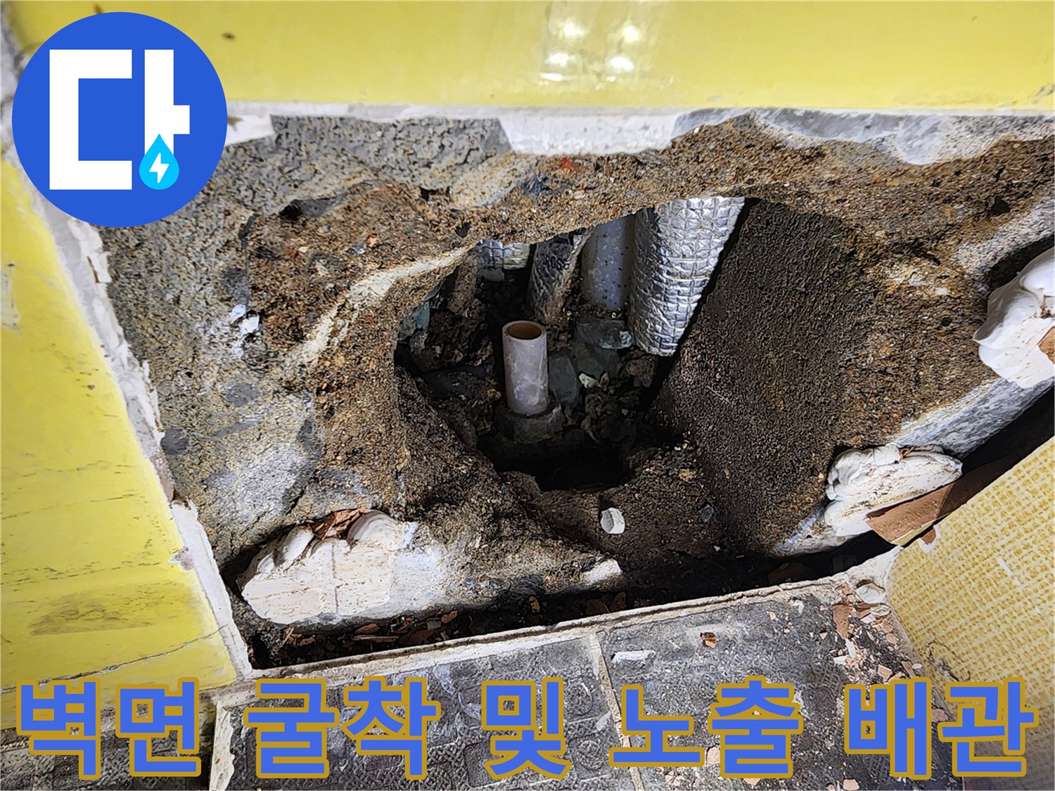 콘크리트 층을 걷어내고 드러난 은색 보온재와 배관