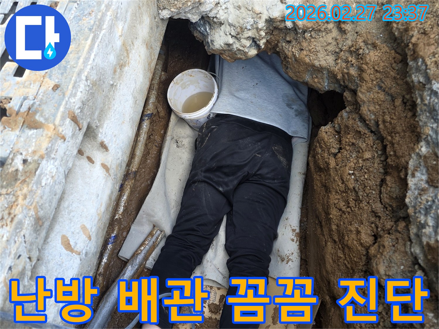 전문 엔지니어가 좁고 어두운 공간에서 난방 배관의 누수 지점을 꼼꼼하게 진단하는 모습
