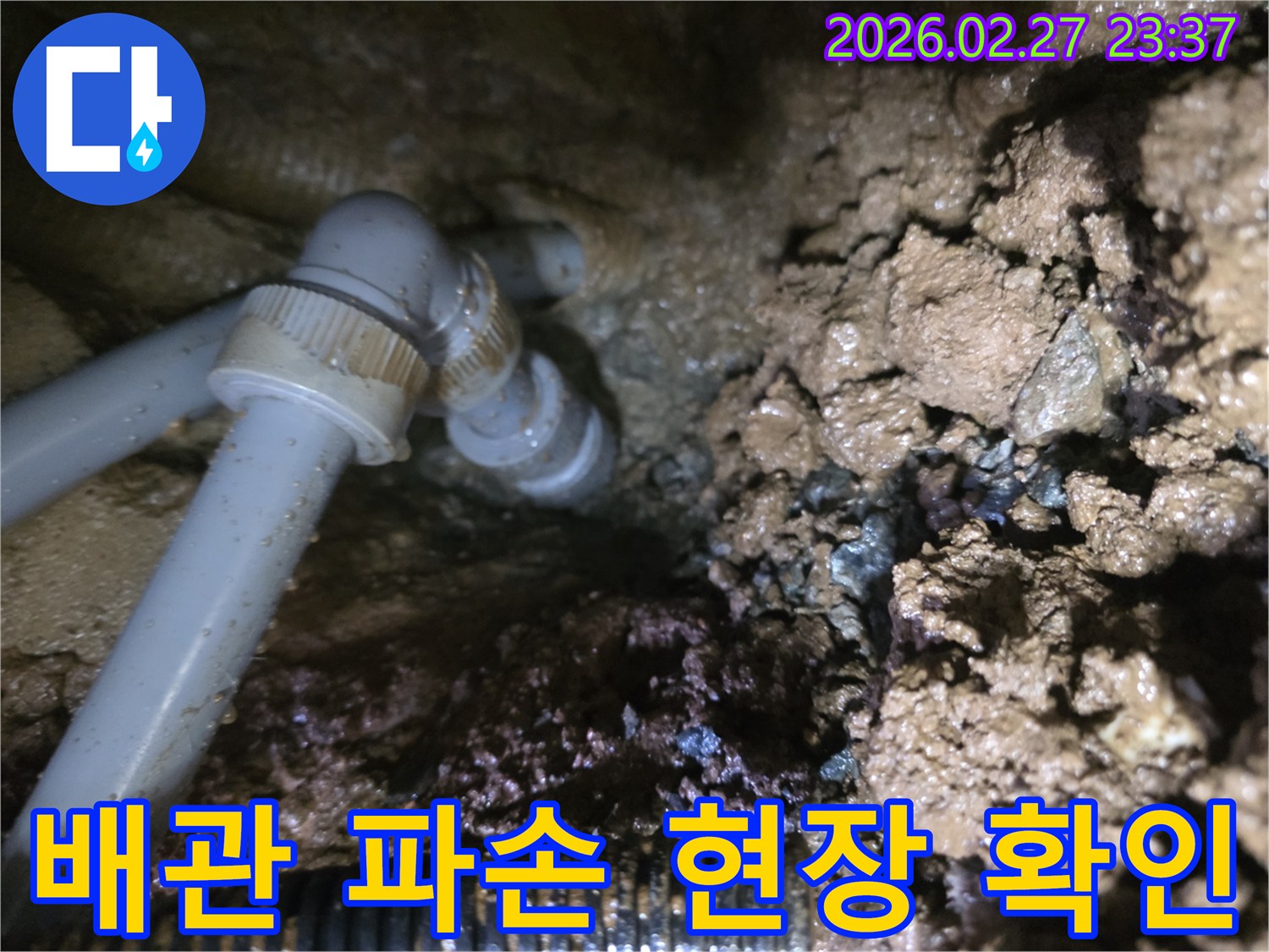 젖은 흙 속에 드러난-파손된 배관의 누수 지점