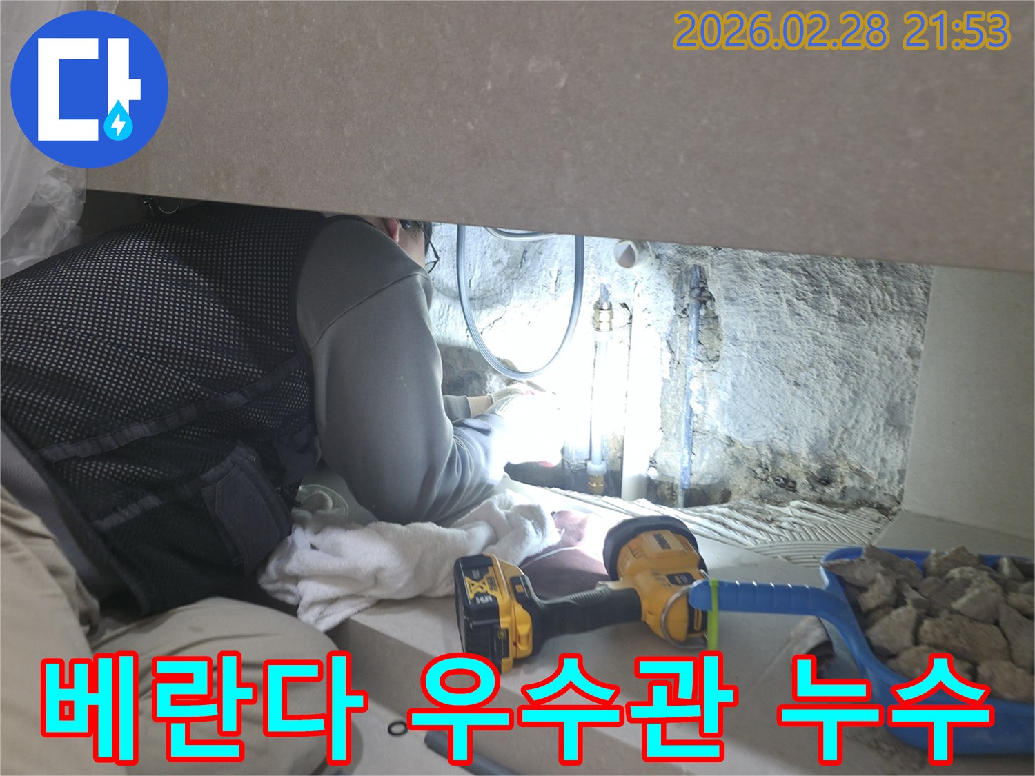 베란다 우수관의-좁은 틈새에서-누수 지점을-찾기 위해-집중하여-작업하는-전문 엔지니어의 모습입니다.