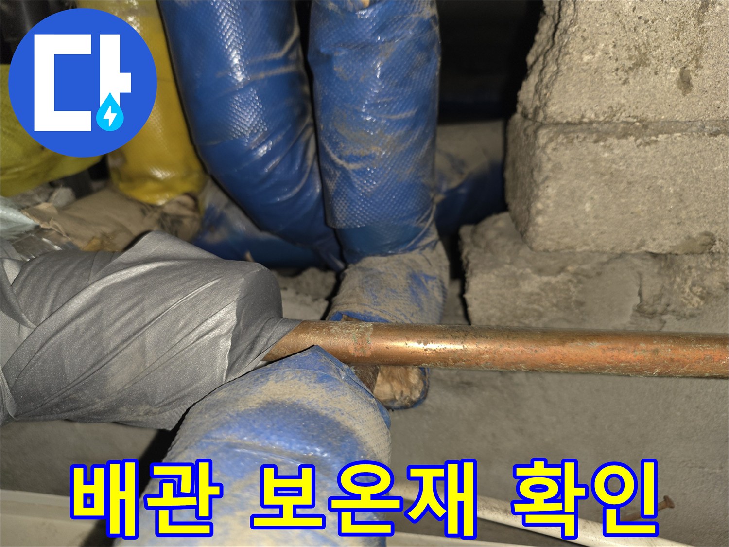 파란색 보온재로 감싸진 구리 배관의 상태를 점검하는 모습