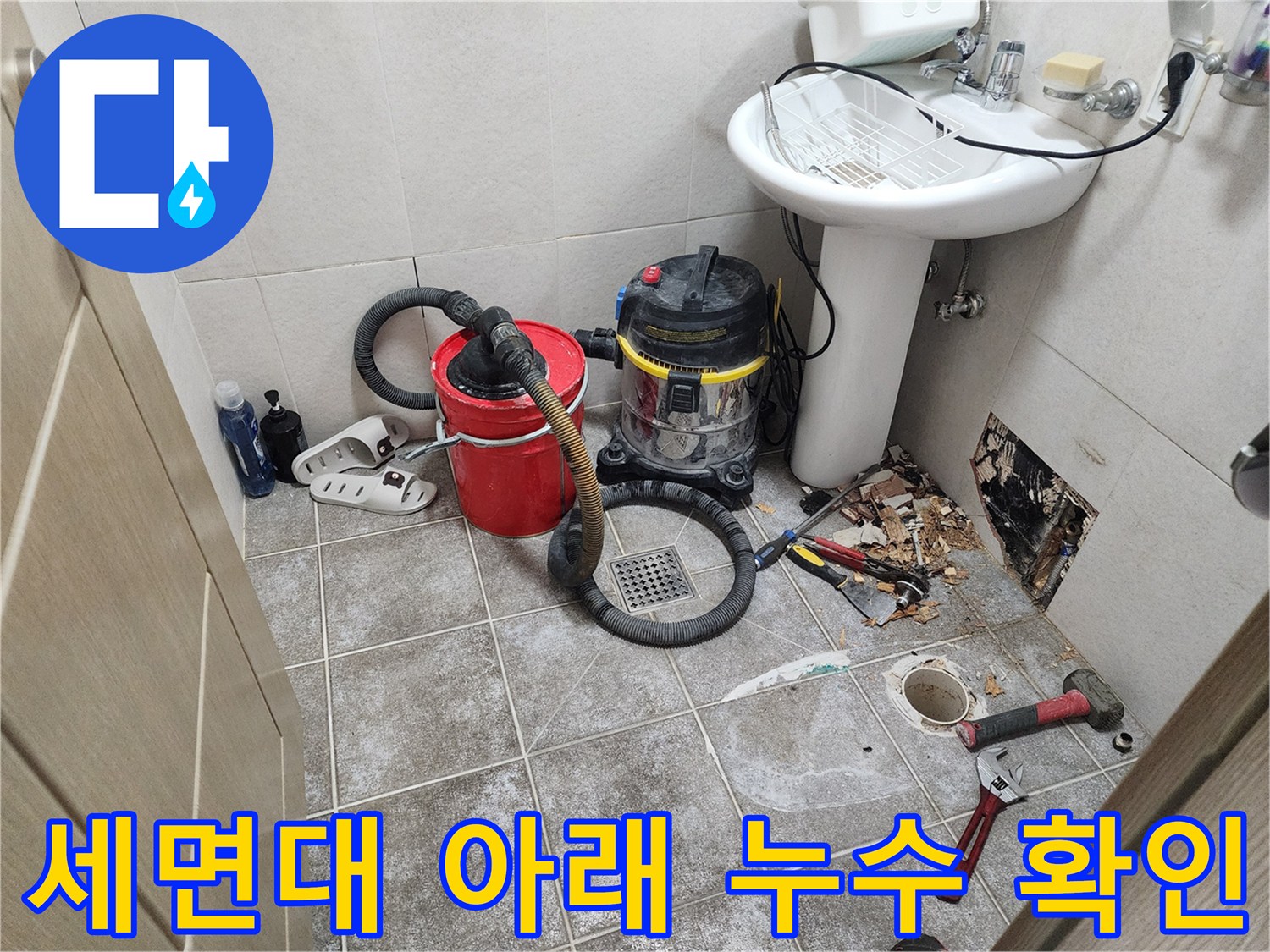 세면대 하단-벽체 내부의 누수 흔적과 작업 도구들