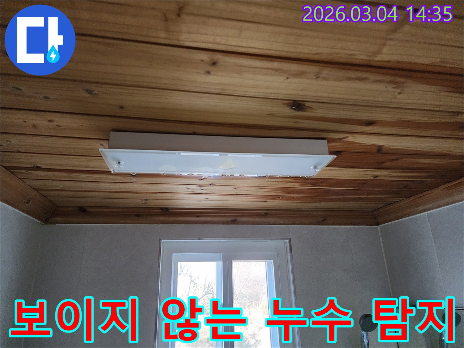 천장 조명 주변으로 물이 스며들어-목재 마감재가 젖어 있는 모습은-보이지 않는 곳에서 진행되는 누수의 증거입니다.