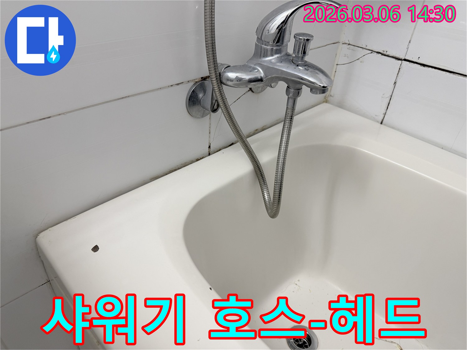 수도꼭지에 연결된 샤워기 호스와-오래된 욕실의 모습입니다.
