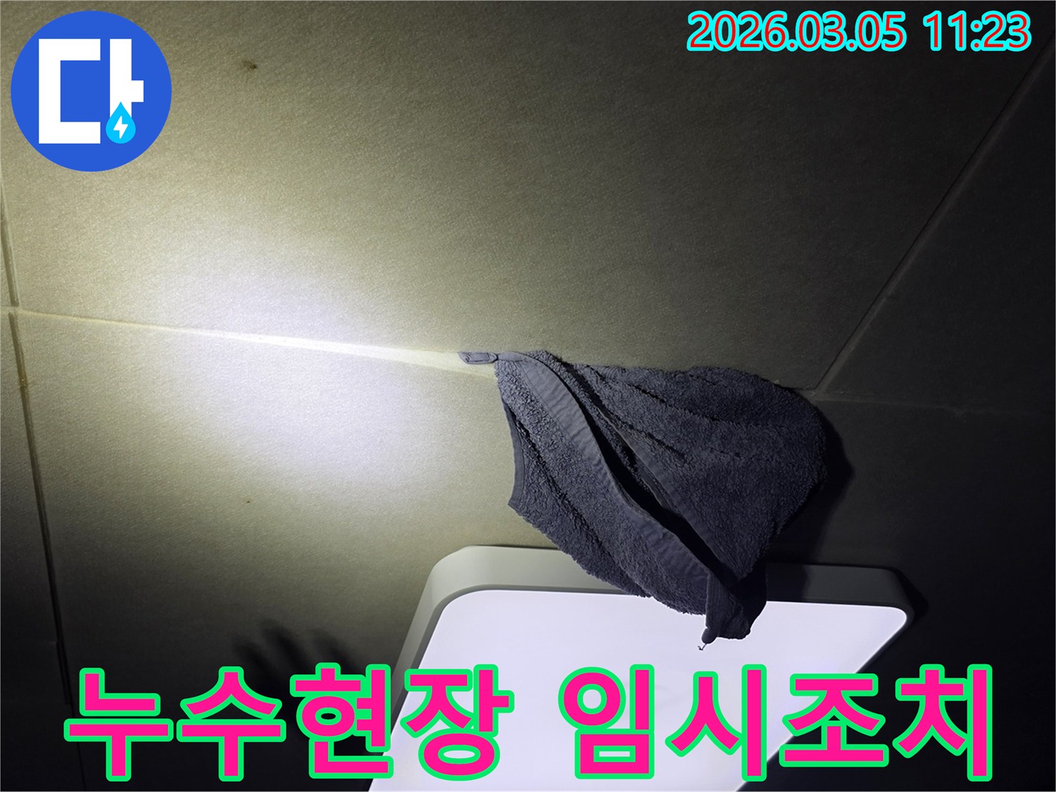 누수로-인해-천장-등기구-주변에-물이-떨어져-수건으로-임시-조치한-모습을-담은-사진