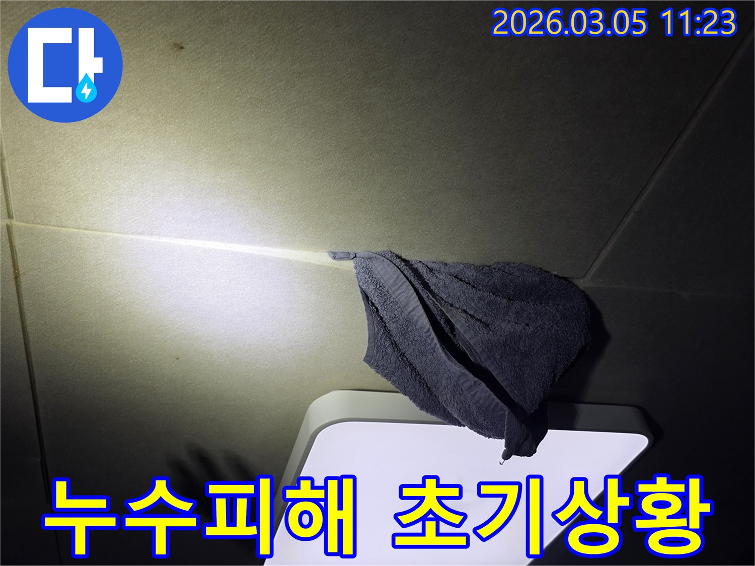 천장에서-물이-새어-나와-수건으로-받고-있는-긴급-누수-상황을-보여주는-이미지
