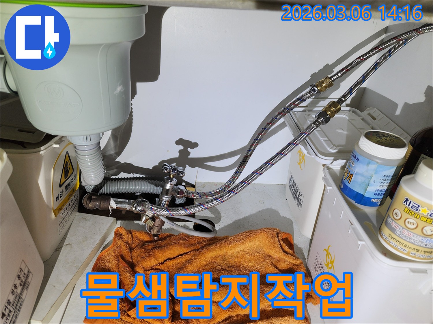 주방 싱크대 아래-수도 배관의-미세한 누수를 확인하는 장면입니다.