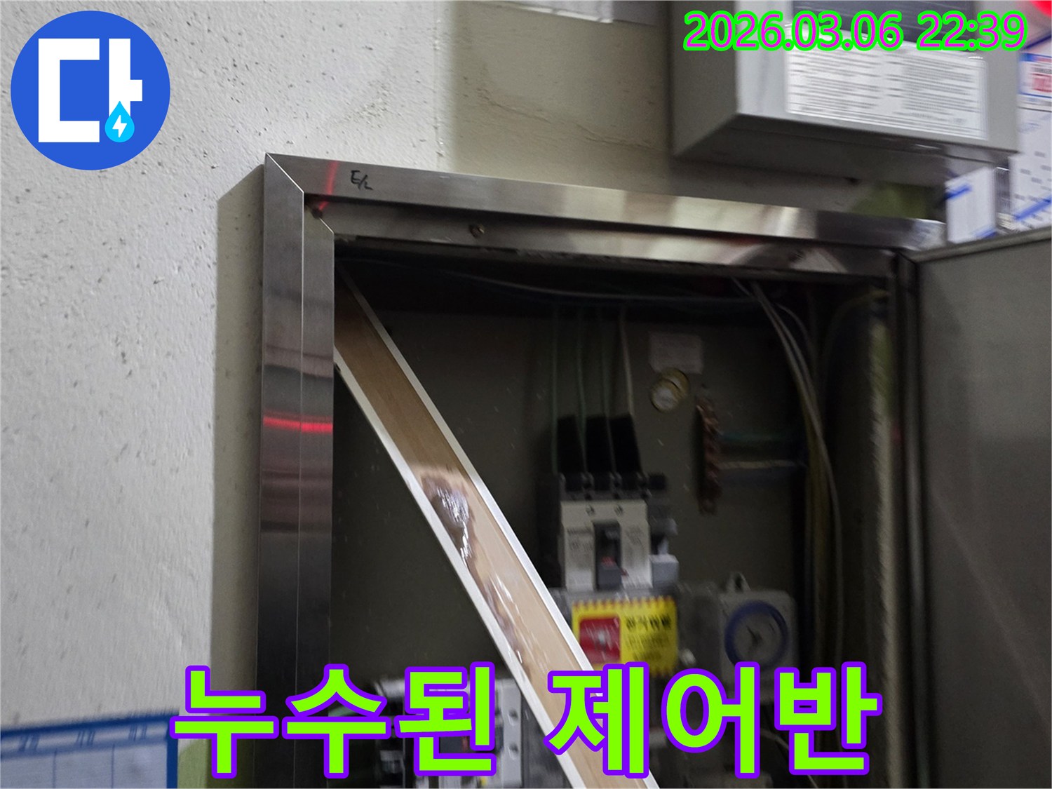 이 이미지는 전기 제어반 내부에서 발견된 심각한 누수 흔적을-보여주며-전기 안전에 대한 위험을-경고합니다.