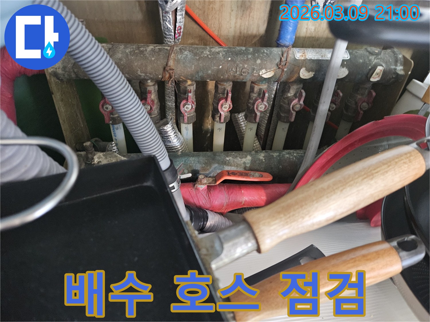 빌라-배수-호스에서-누수-여부를-확인하기-위해-전문-기술자가-점검하는-모습