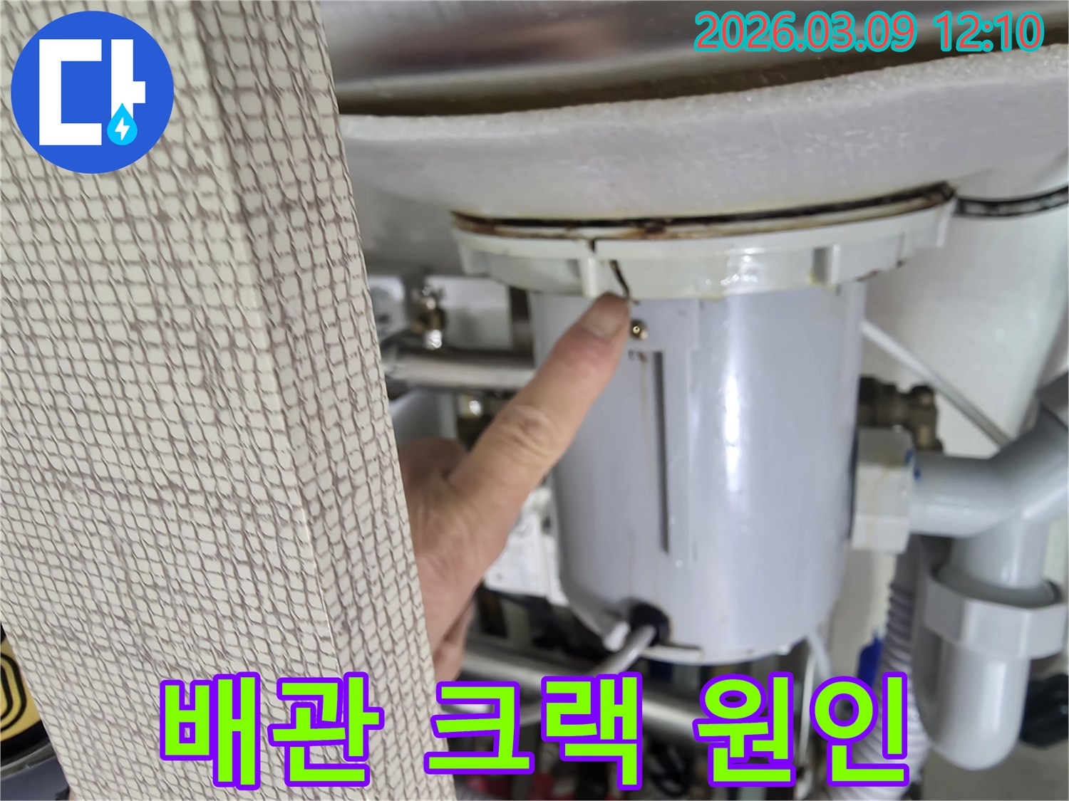 누수 전문가가-배관에 발생한-미세한 크랙을-누수 원인으로-지목하며-고객에게-설명하는-장면입니다.