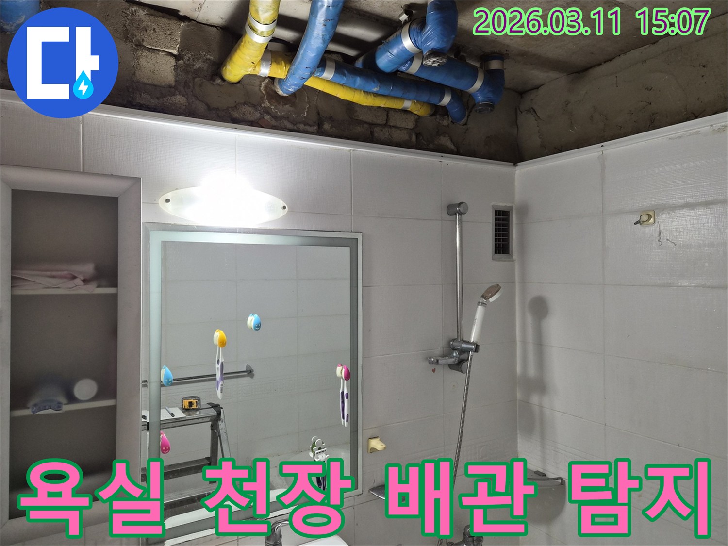 욕실 천장 속-파란색과 노란색 배관들이-누수 탐지를 위해-노출된 모습