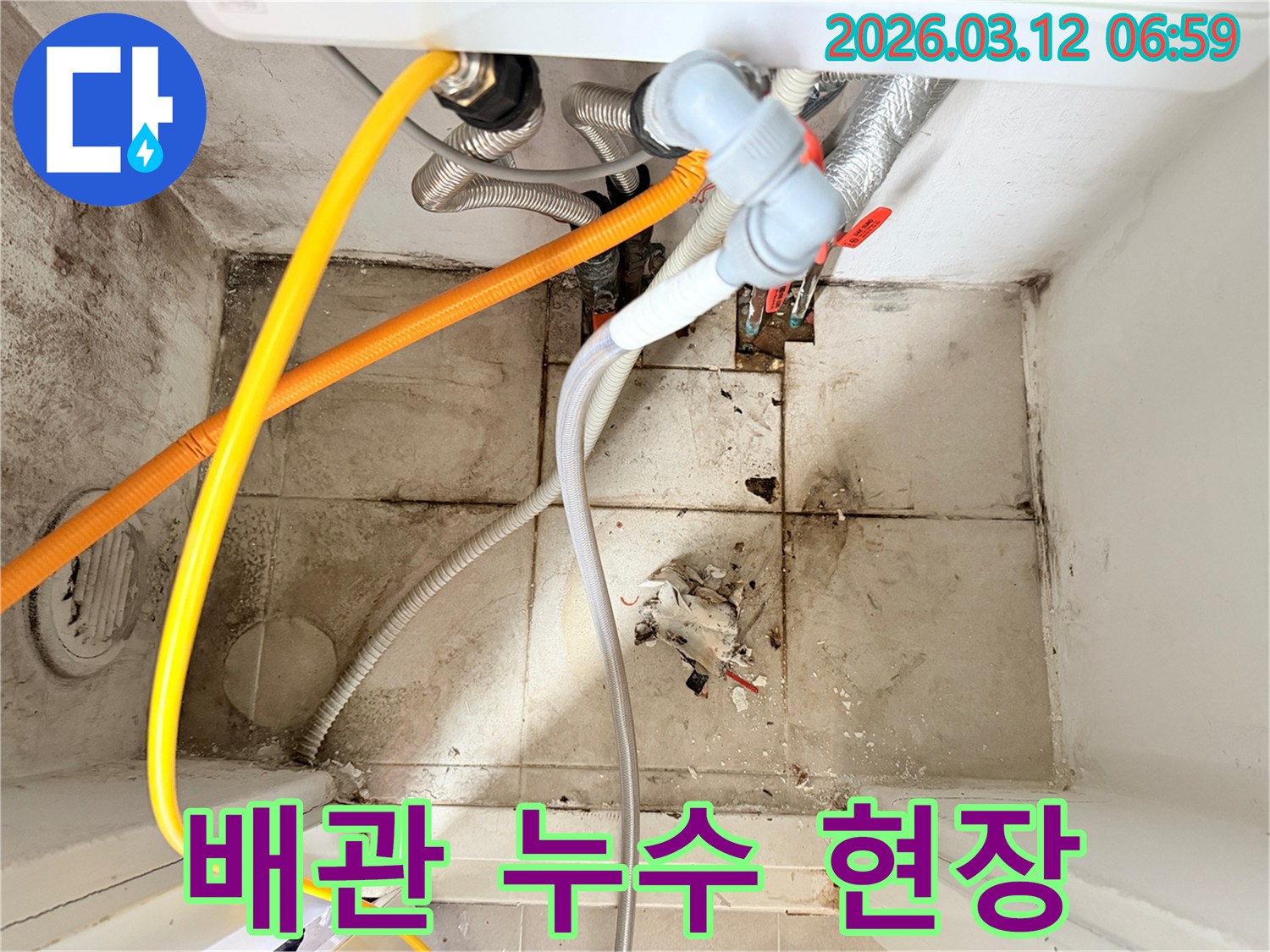 다양한 배관들이 얽혀있고-바닥과 벽면에-오염과 곰팡이가 보이는-누수 현장 모습입니다.