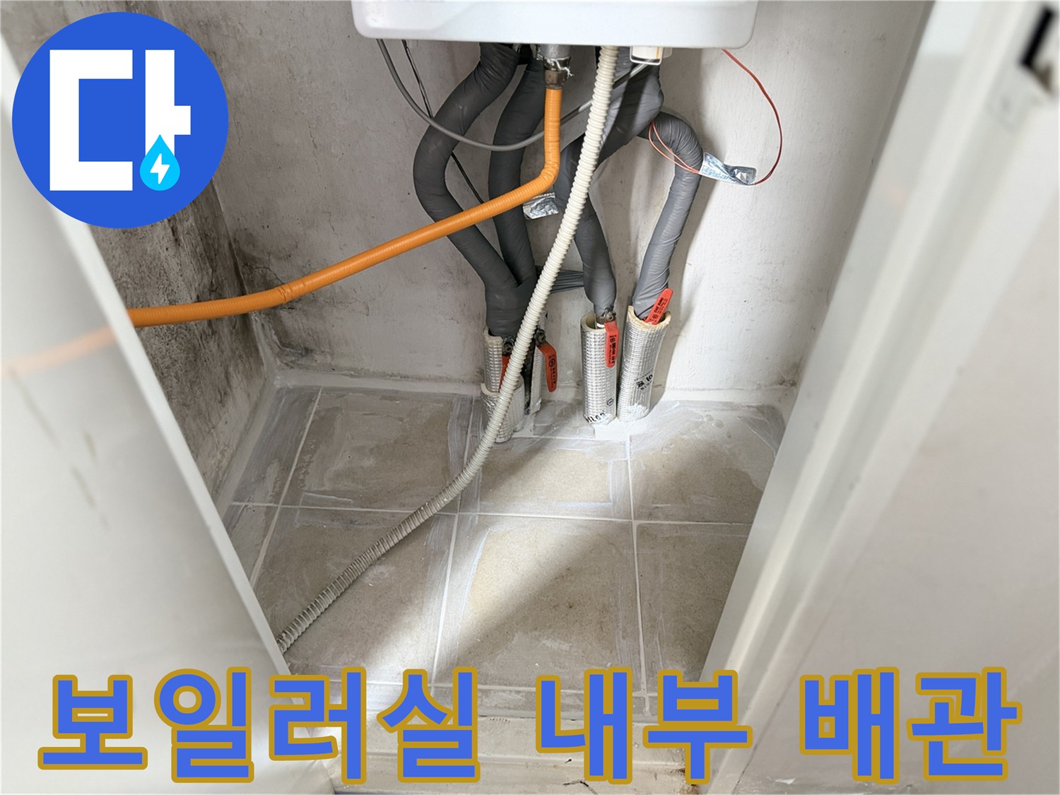보일러-하단-회색-및-주황색-배관의-복잡한-연결-부위