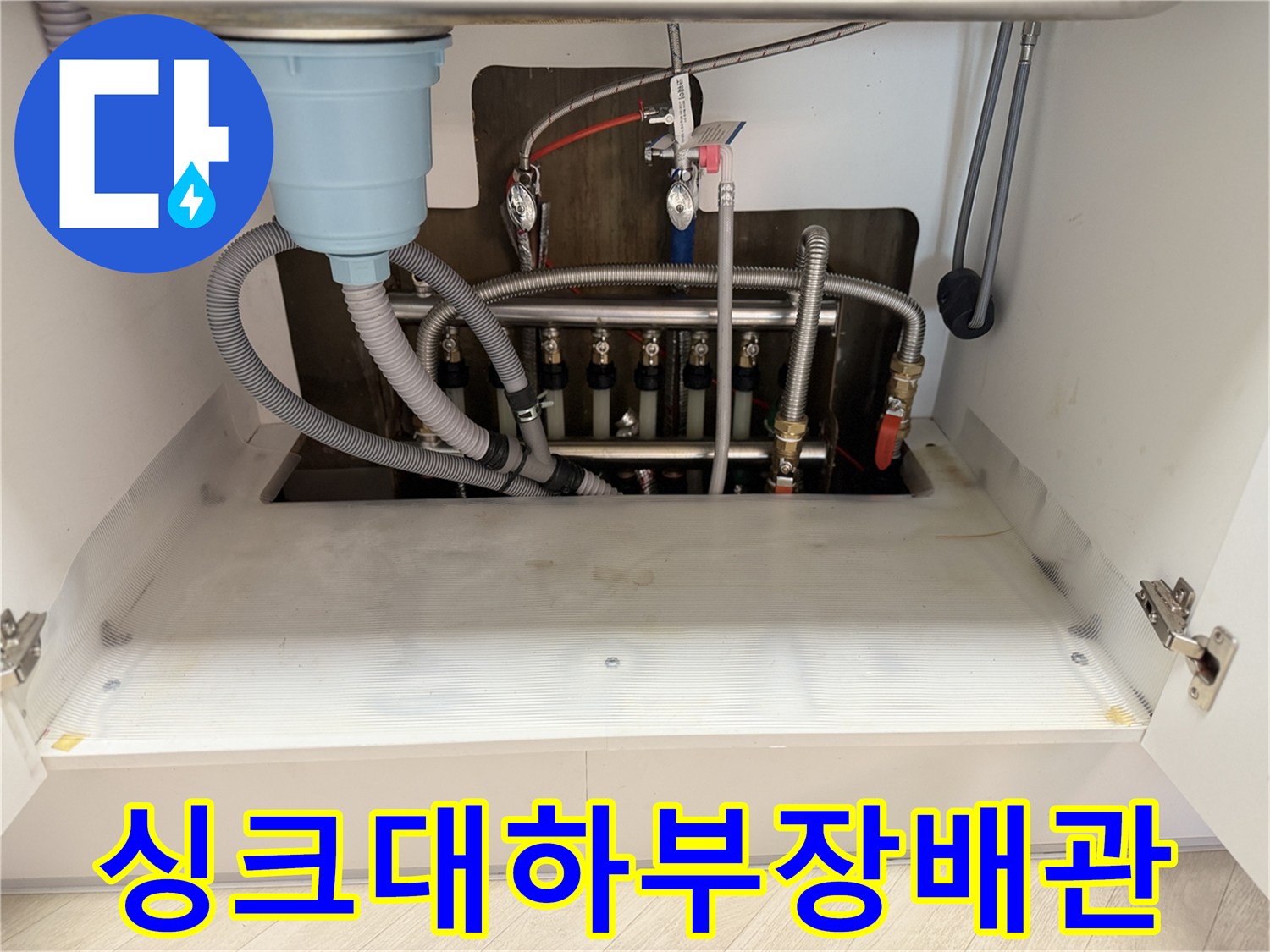싱크대 하부장에 노출된 난방 분배기와 배관 연결 상태