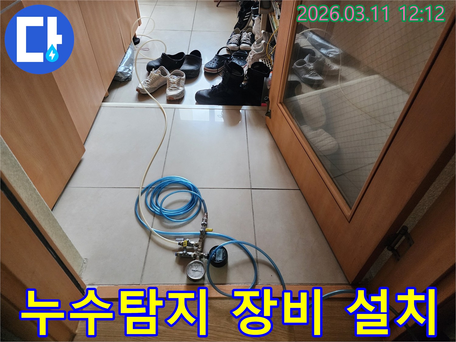 누수 탐지 작업을 위해 압력 게이지가 달린 호스를 연결하고 있는 모습