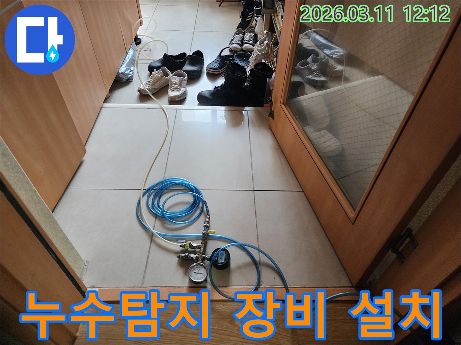 누수 탐지 작업을 위해 압력 게이지가 달린 호스를 연결하고 있는 모습