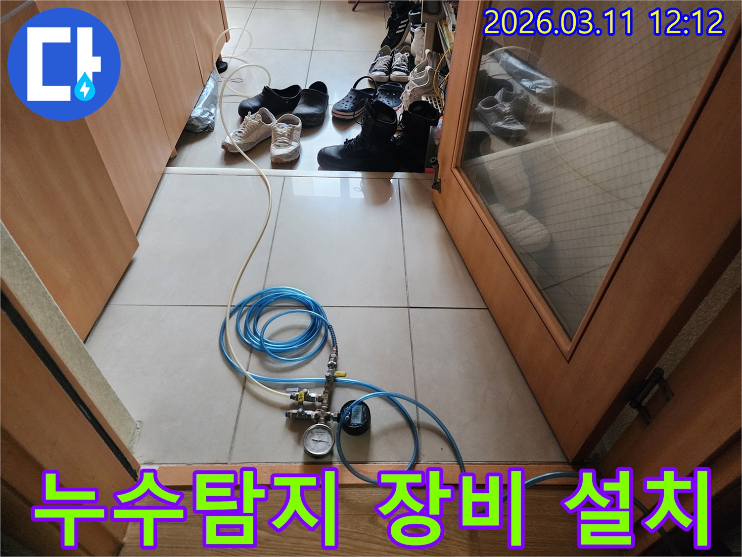 누수 탐지 작업을 위해 압력 게이지가 달린 호스를 연결하고 있는 모습