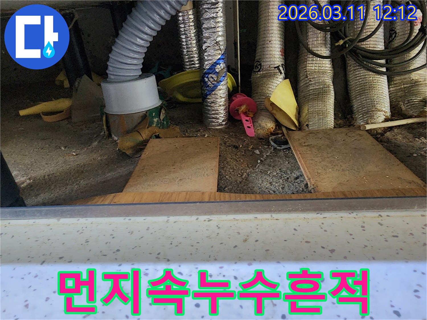 먼지와-이물질-속에-숨겨진-미세한-누수-흔적을-찾기-위해-전문가가-꼼꼼히-살피는-모습을-담은-사진입니다