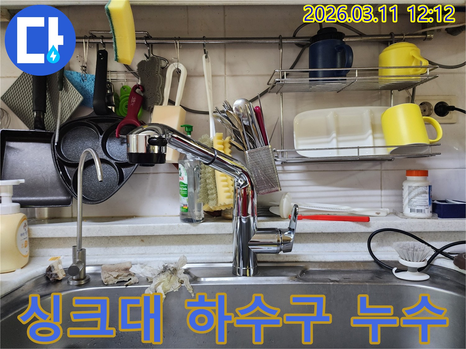 싱크대 배수구 근처에서-발견된 물기 흔적을-누수 전문가가-면밀히 관찰하는 모습